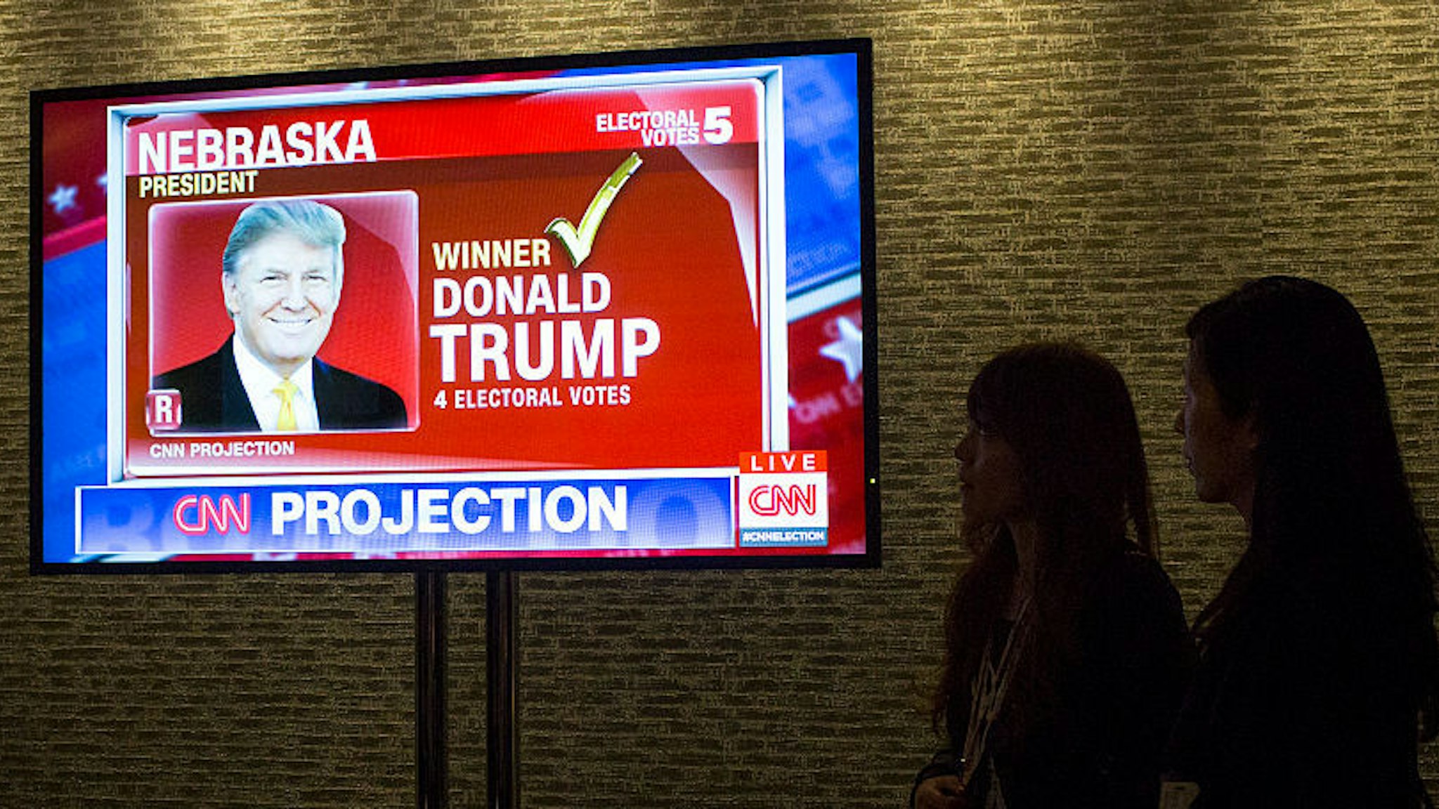 Two Japanese journalists watch the television screen image of Donald J Trump appears on a CNN program after the Republican party presidential nominee wins the vote from the state of Nebraska November 9, 2016 at the Hilton Hotel in New York City. (Photo by Robert Nickelsberg/Getty Images)