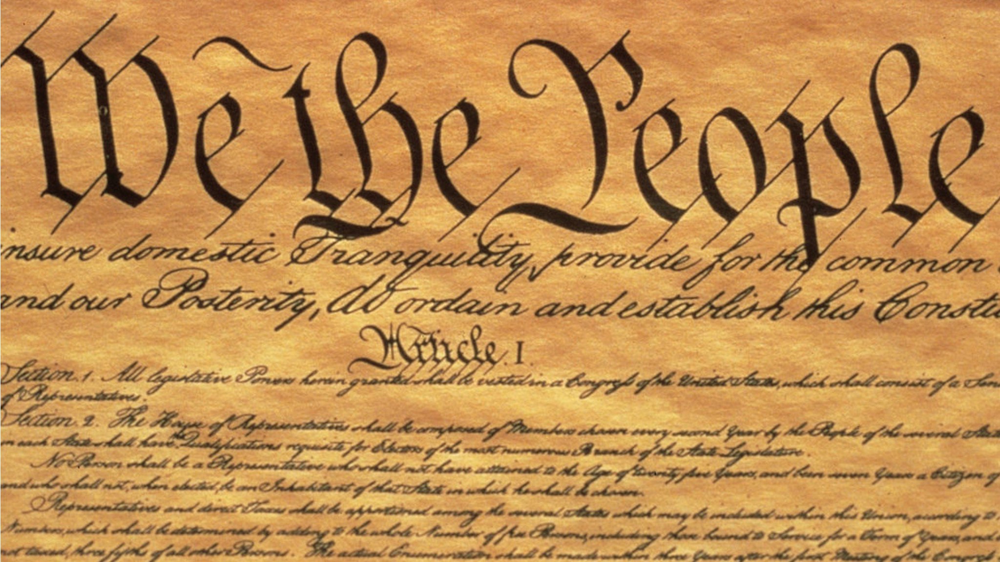 This is the Preamble to the US Constitution, It starts with the phrase We The People and shows only some of the writing from the upper left hand corner of the document of the Constitution, It is written on parchment paper that is now faded...