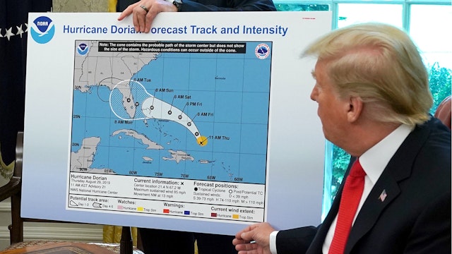 U.S. President Donald Trump (R) references a map held by acting Homeland Security Secretary Kevin McAleenan while talking to reporters following a briefing from officials about Hurricane Dorian in the Oval Office at the White House September 04, 2019...
