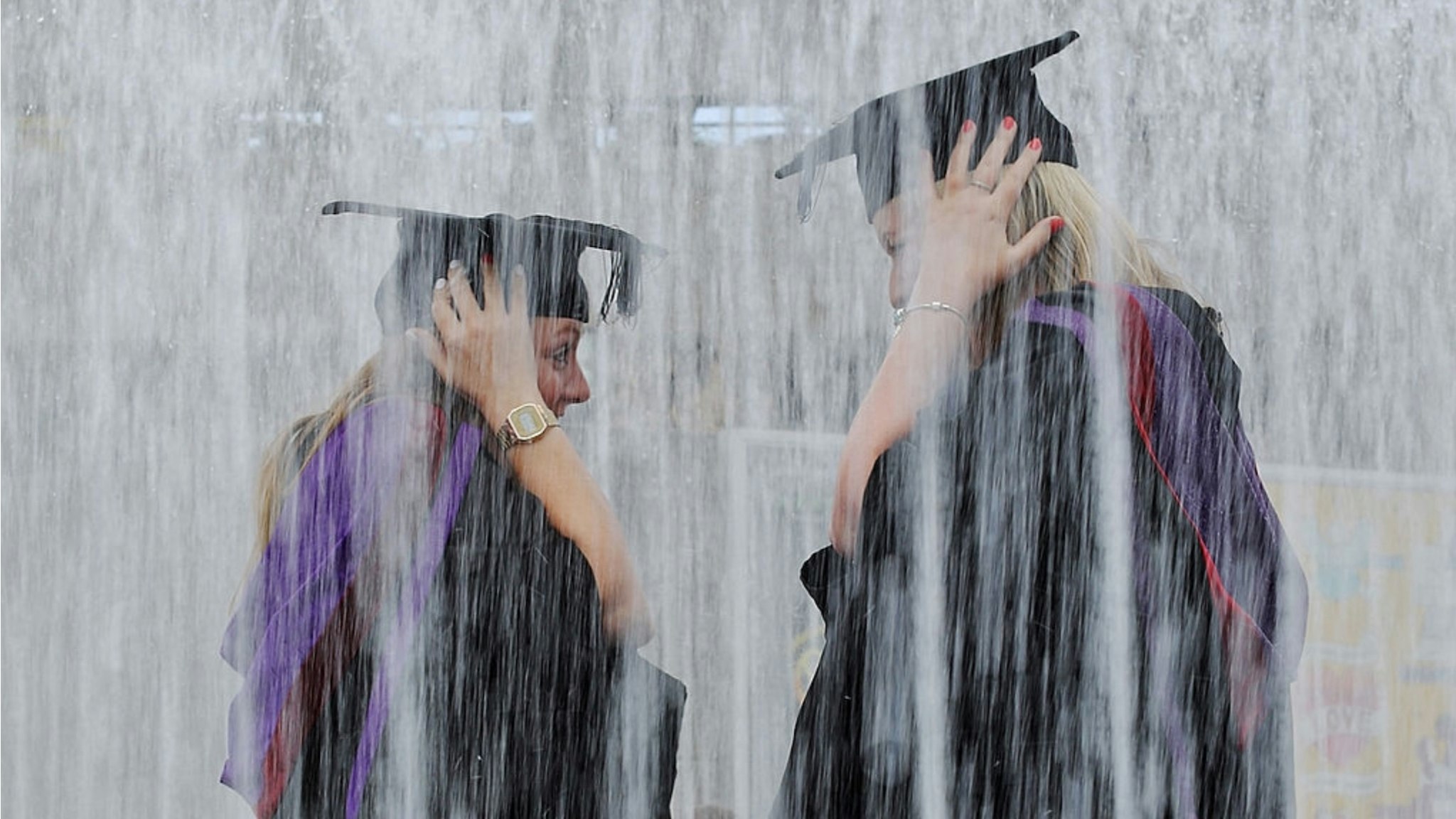 Students stand in a fountain ahead of their graduation ceremony at the Royal Festival Hall on July 15, 2014 in London, England.