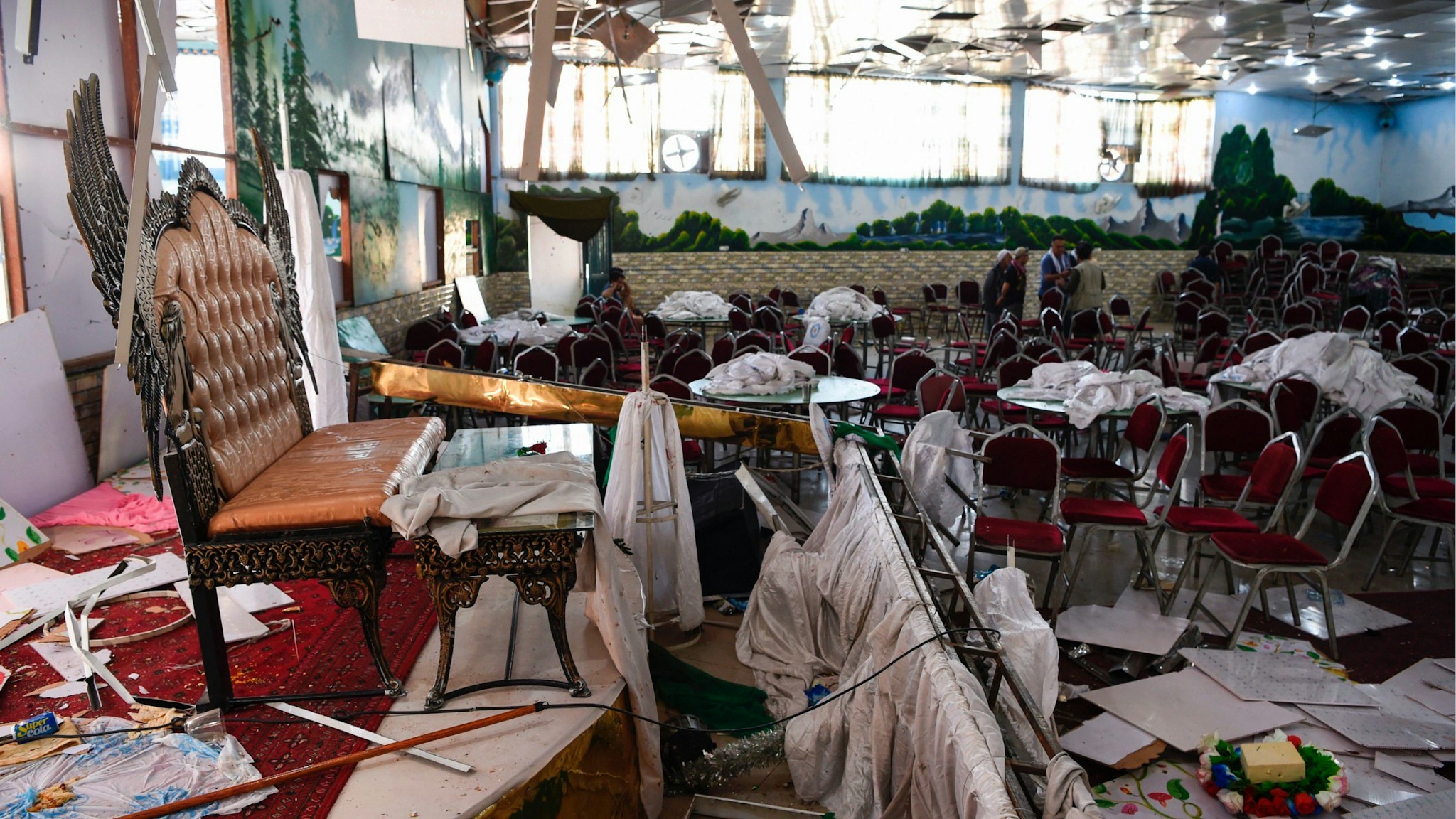 Afghan men investigate in a wedding hall after a deadly bomb blast in Kabul on August 18, 2019.