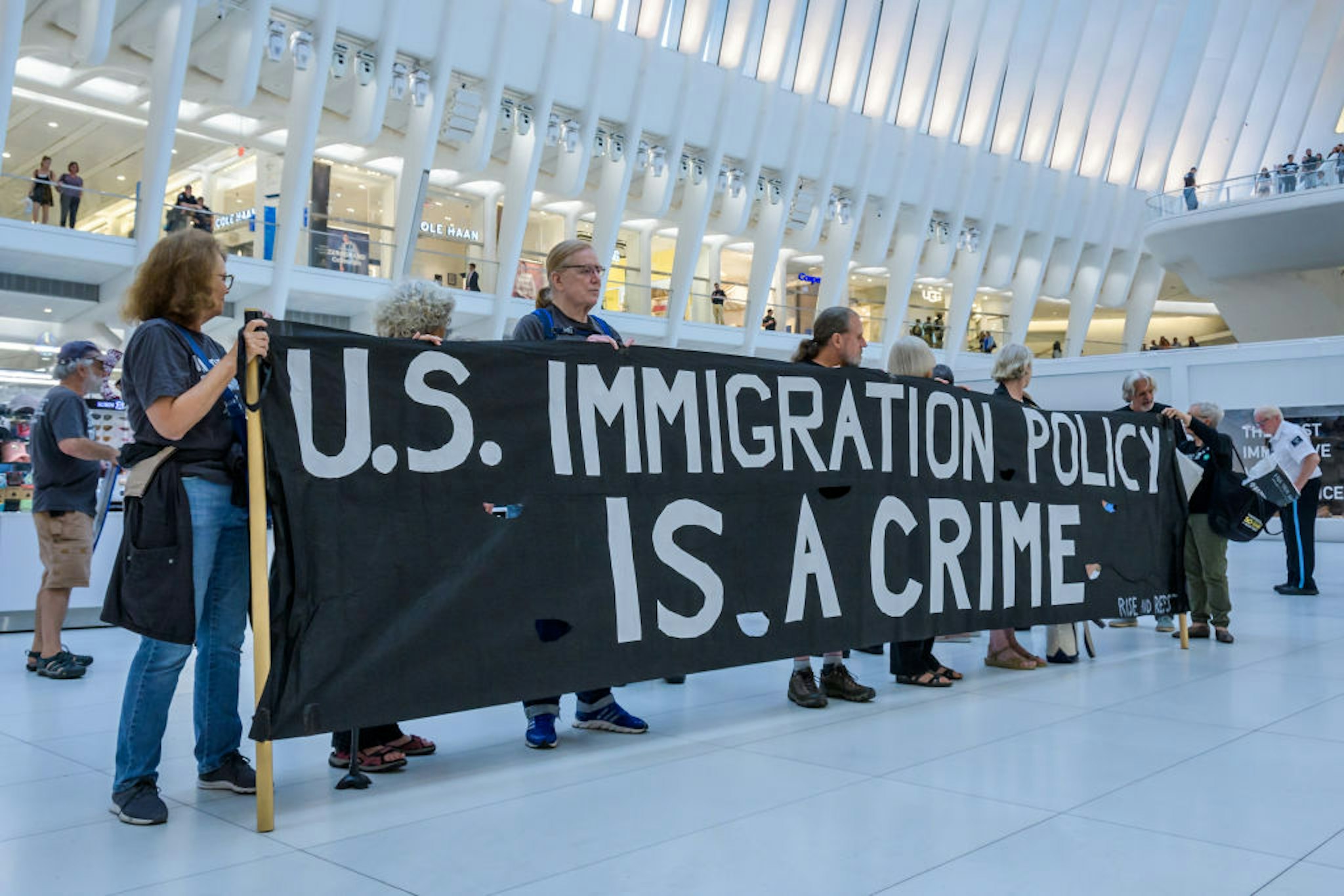 Members of the activist group Rise And Resist gathered at a silent protest inside The Oculus on September 12, 2019 holding NO RAIDS/CLOSE THE CAMPS/ABOLISH ICE banners, photographs of the children who have died in ICE custody, and photographs of the detention camps to object to Border Patrol and ICE treatment of immigrants, refugees, and asylum seekers.