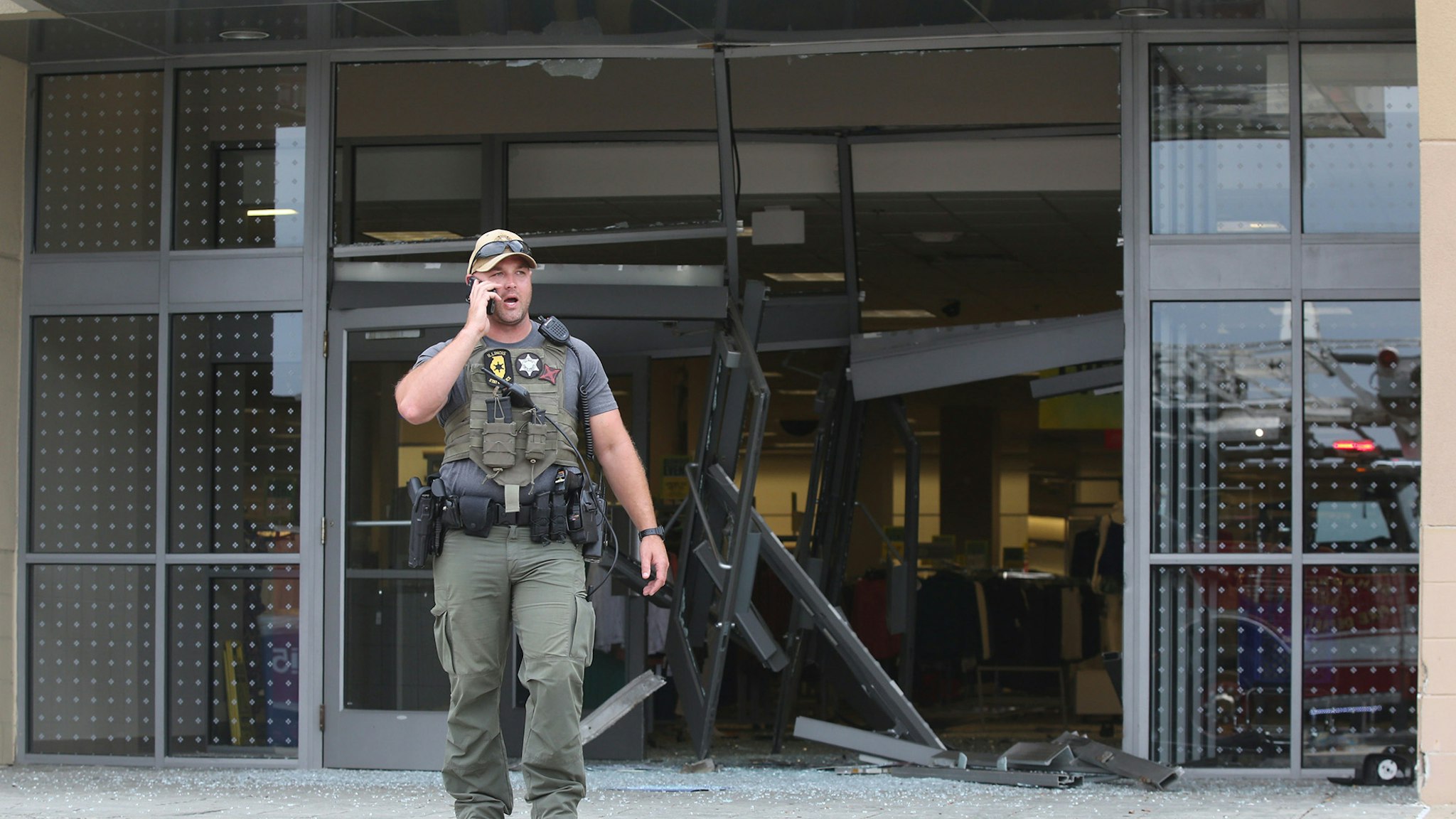 A state police officer stands outside of a Woodfield Mall entrance on Friday, Sept. 20, 2019, in Schaumberg, Ill. A vehicle drove into the mall on Friday through one of the Sears' entrances.