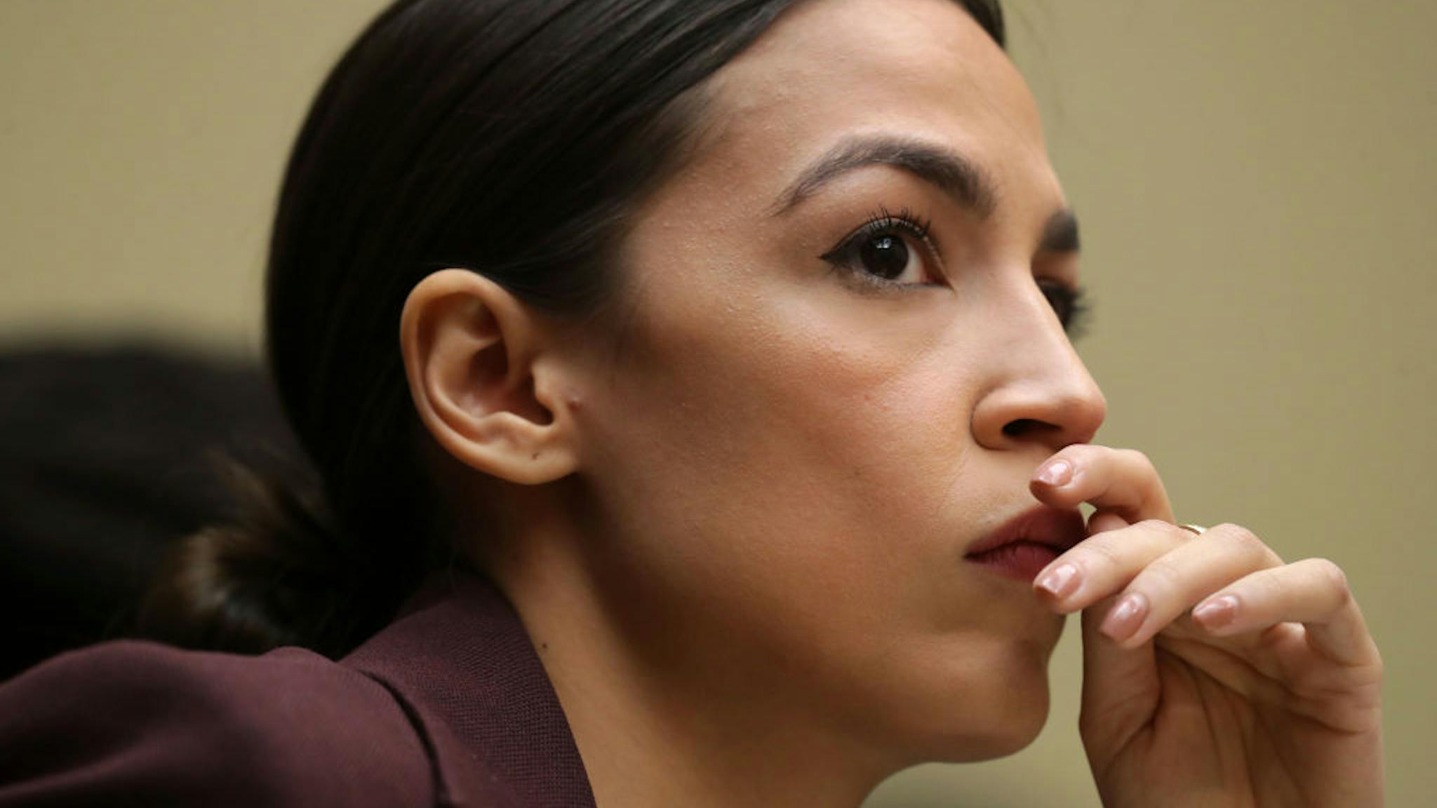 AOC WASHINGTON, DC - FEBRUARY 27: Rep. Alexandria Ocasio-Cortez (D-NY) listens to testimony by Michael Cohen, former attorney and fixer for President Donald Trump, before the House Oversight Committee on Capitol Hill February 27, 2019 in Washington, DC. Last year Cohen was sentenced to three years in prison and ordered to pay a $50,000 fine for tax evasion, making false statements to a financial institution, unlawful excessive campaign contributions and lying to Congress as part of special counsel Robert Mueller's investigation into Russian meddling in the 2016 presidential elections.