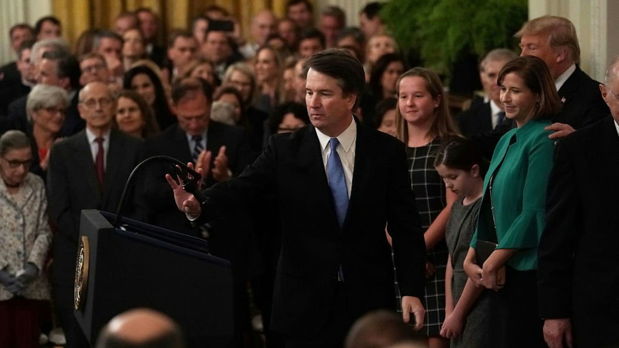 U.S. Supreme Court Justice Brett Kavanaugh (C) takes the podium as his wife Ashley (2nd R), daughters Liza (4th R) and Margaret (3rd R), and President Donald Trump (R) look on during a ceremonial swearing in at the White House October 8, 2018.