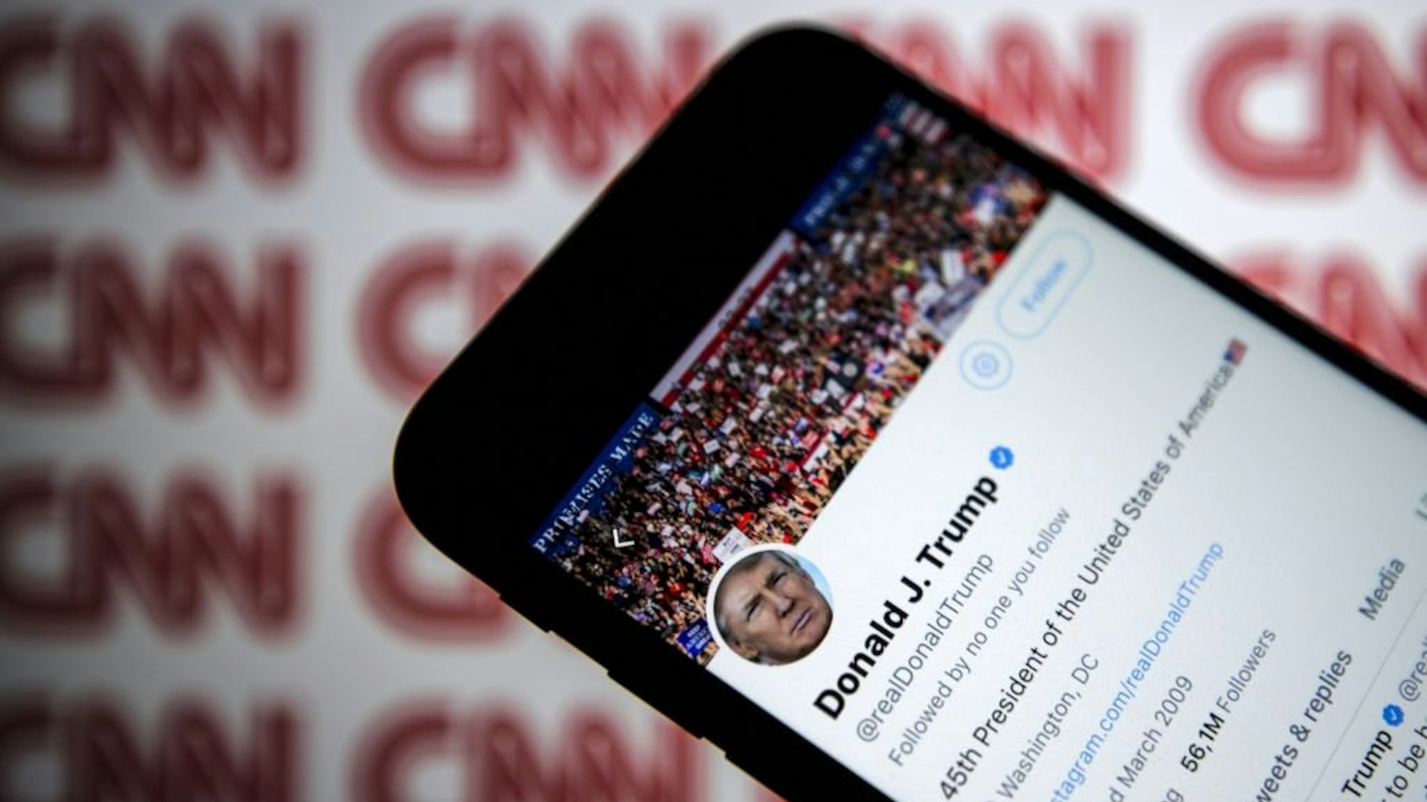 Donald Trump's Twitter profile is seen on a smartphone against a backdrop with the CNN logo, in Ankara, Turkey on December 9, 2018.