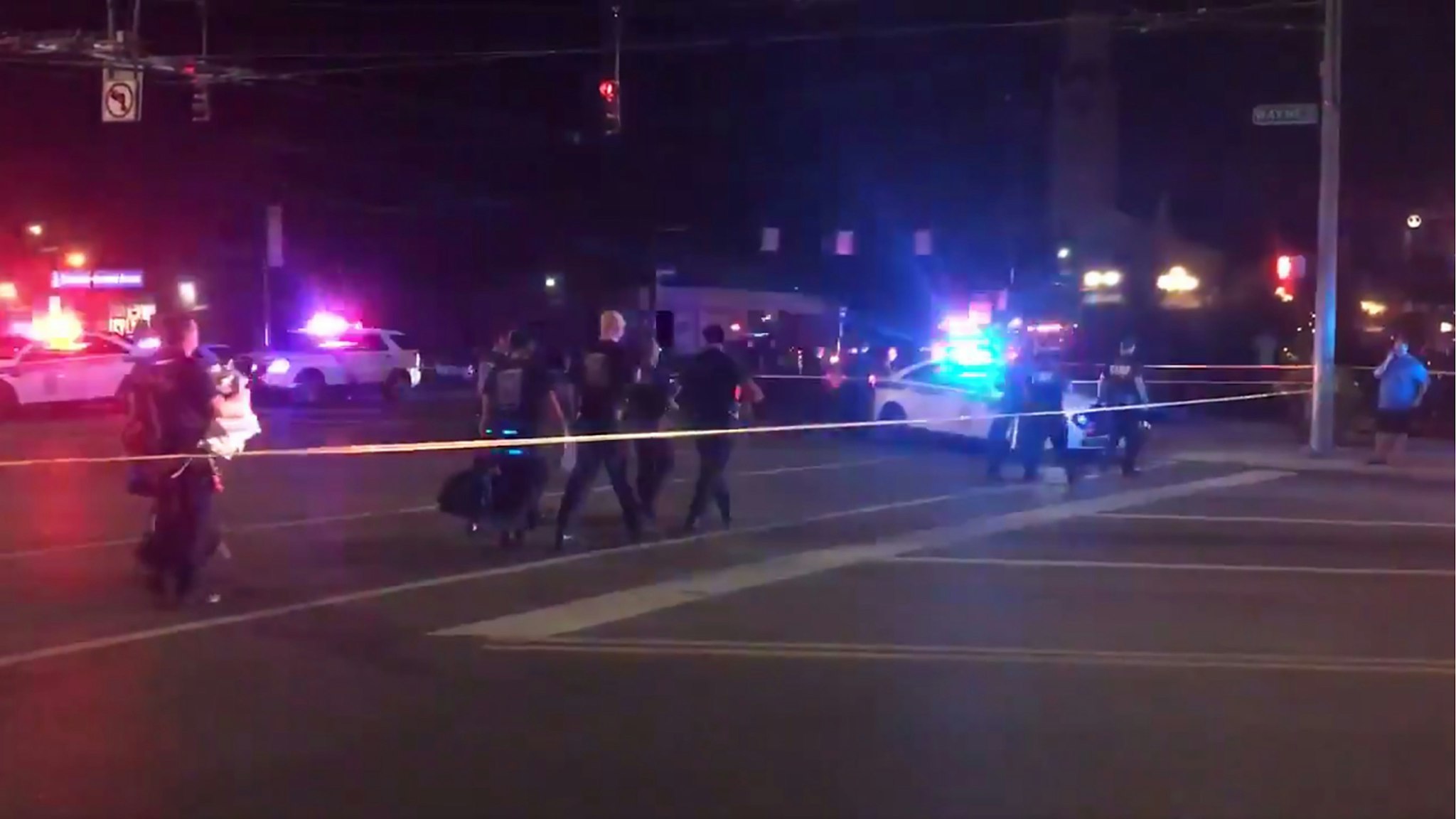 This videograb taken from the Twitter account of Derek Myers on August 4, 2019 shows police officers walking behind police cordon following a mass shooting in the popular bar and nightlife Oregon district in Dayton, Ohio.