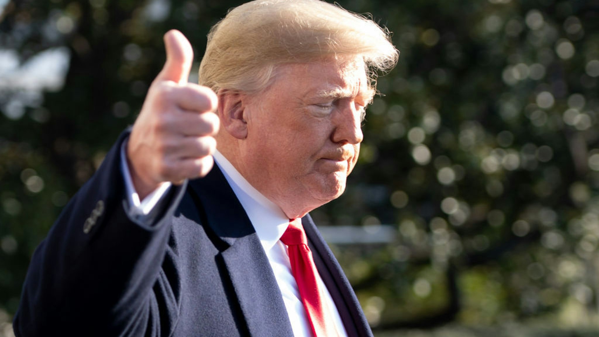 US President Donald Trump gives a thumbs-up as he speaks to the press as he walks to Marine One prior to departing from the South Lawn of the White House in Washington, DC, December 7, 2018.