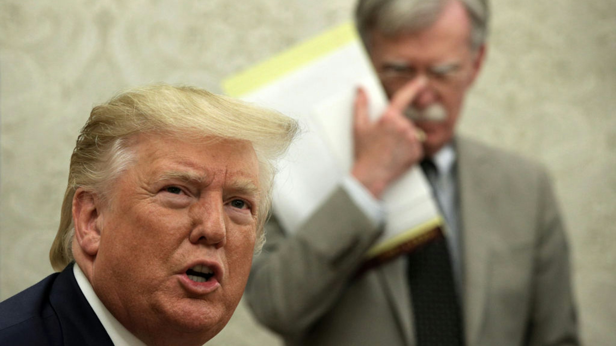 WASHINGTON, DC - AUGUST 20: U.S. President Donald Trump speaks to members of the media as National Security Adviser John Bolton listens during a meeting with President of Romania Klaus Iohannis in the Oval Office of the White House August 20, 2019 in Washington, DC. This is Iohannis‚Äô second visit to the Trump White House and the two leaders are expected to discuss bilateral issues during their meeting.