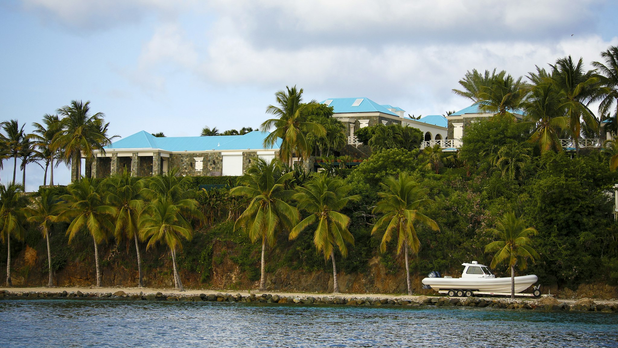 A house stands above a boat on Little St. James Island, owned by fund manager Jefferey Epstein, in St. Thomas, U.S. Virgin Islands, on Wednesday, July 10, 2019. This is where Epstein - convicted of sex crimes a decade ago in Florida and now charged in New York with trafficking girls as young as 14 - repaired, his escape from the toil of cultivating the rich and powerful.