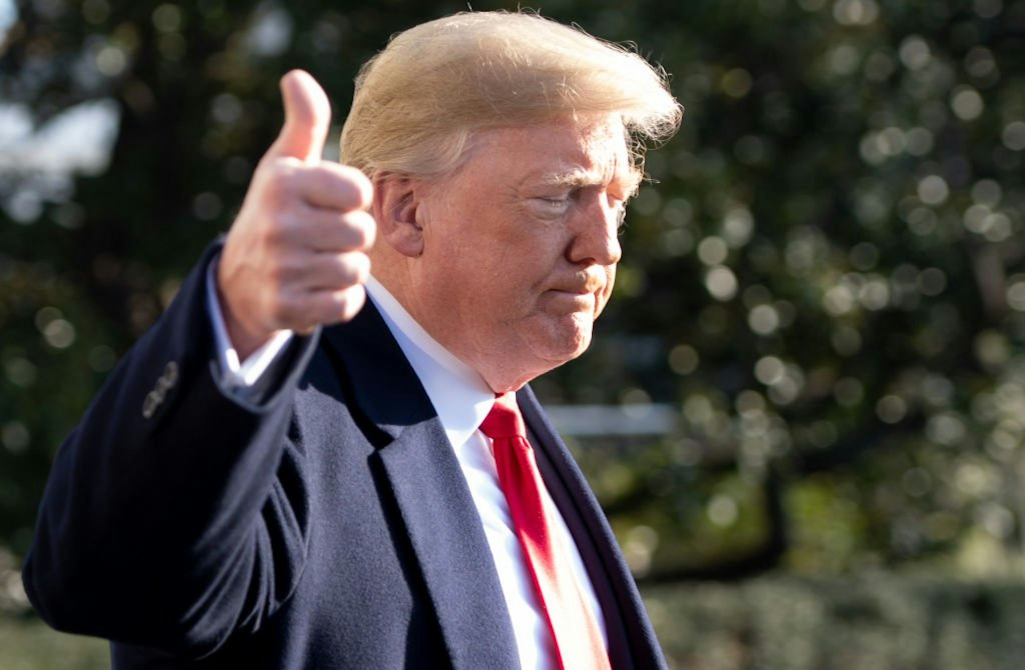 US President Donald Trump gives a thumbs-up as he speaks to the press as he walks to Marine One prior to departing from the South Lawn of the White House in Washington, DC, December 7, 2018.