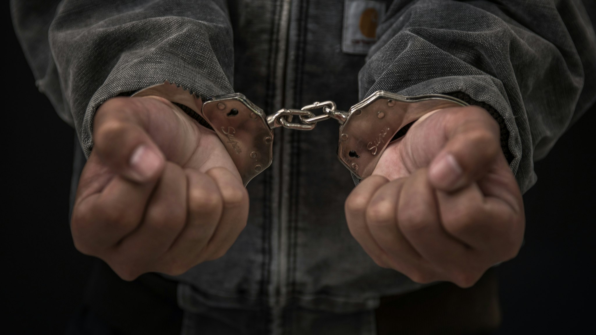 Upset handcuffed man imprisoned for financial crime, punished for serious fraud.