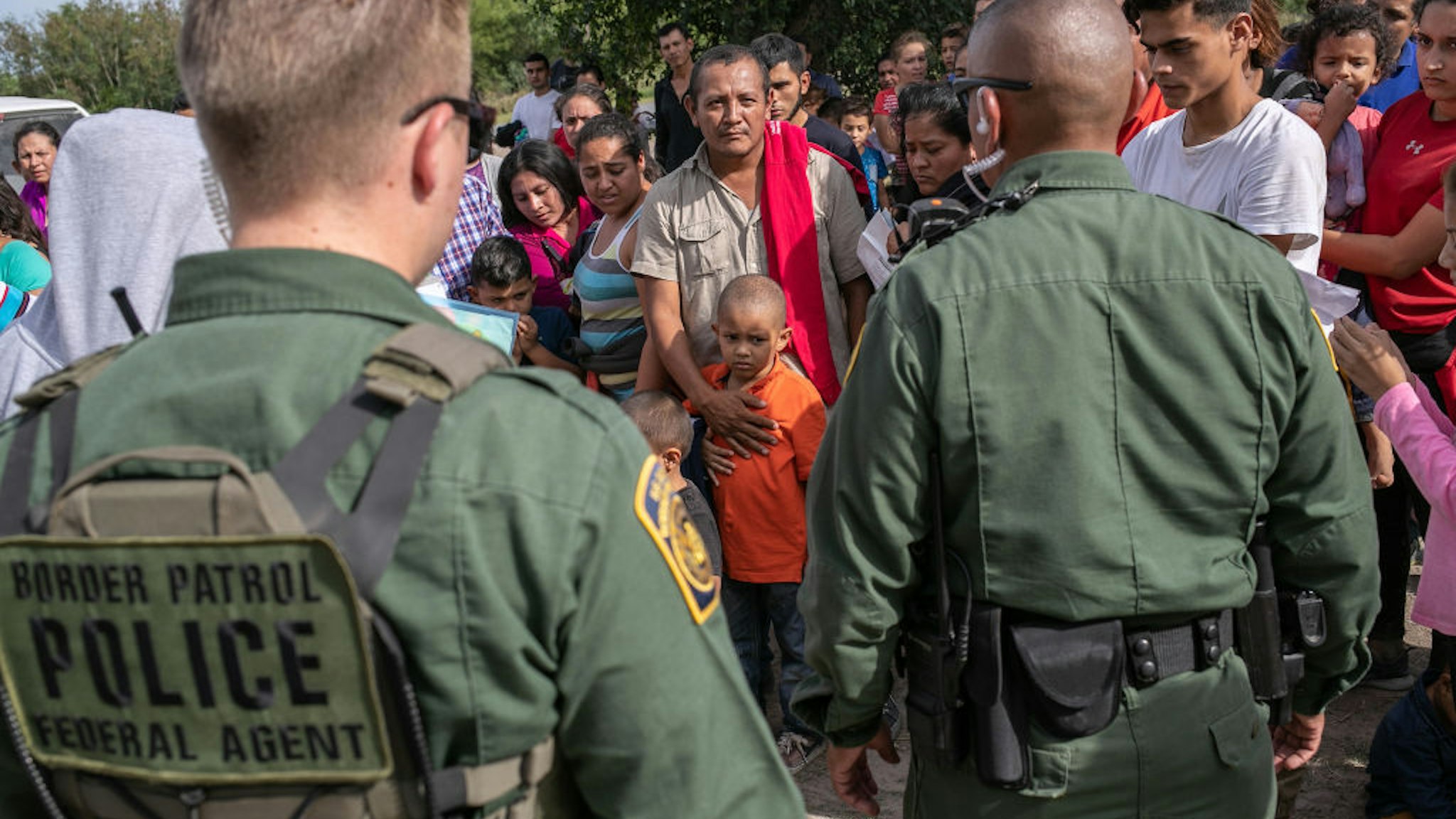U.S. Border Patrol agents watch over immigrants after taking them into custody on July 02, 2019 in Los Ebanos, Texas.