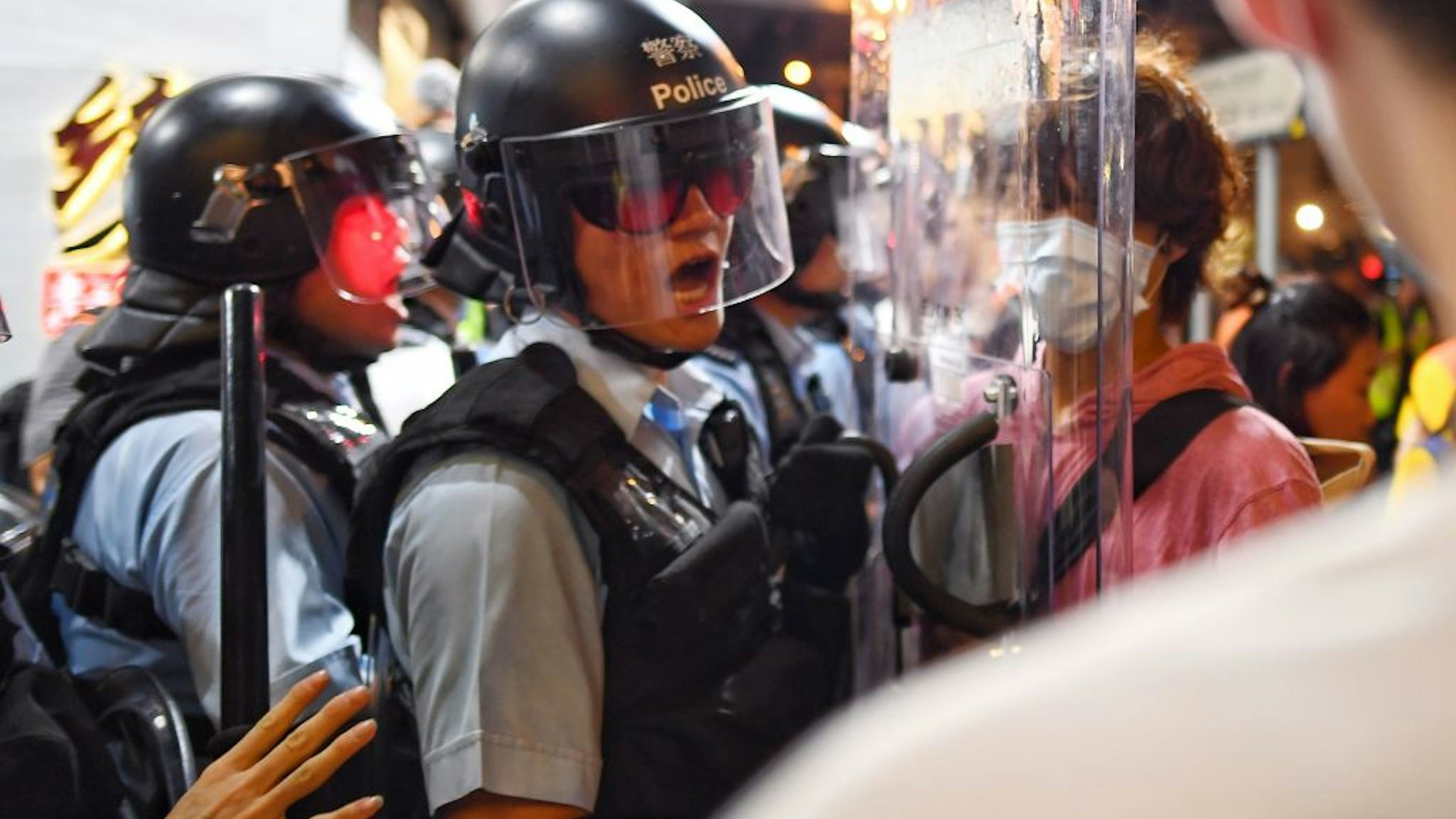 A Police man (L) shouts at a Pro-Democracy Protestor (R) to move out of his way during a gathering in the Sham Shui Po Area of Hong Kong on August 14, 2019. - More than 10 weeks of sometimes-violent demonstrations have wracked the semi-autonomous city, with millions taking to the streets to demand democratic reforms and police accountability.