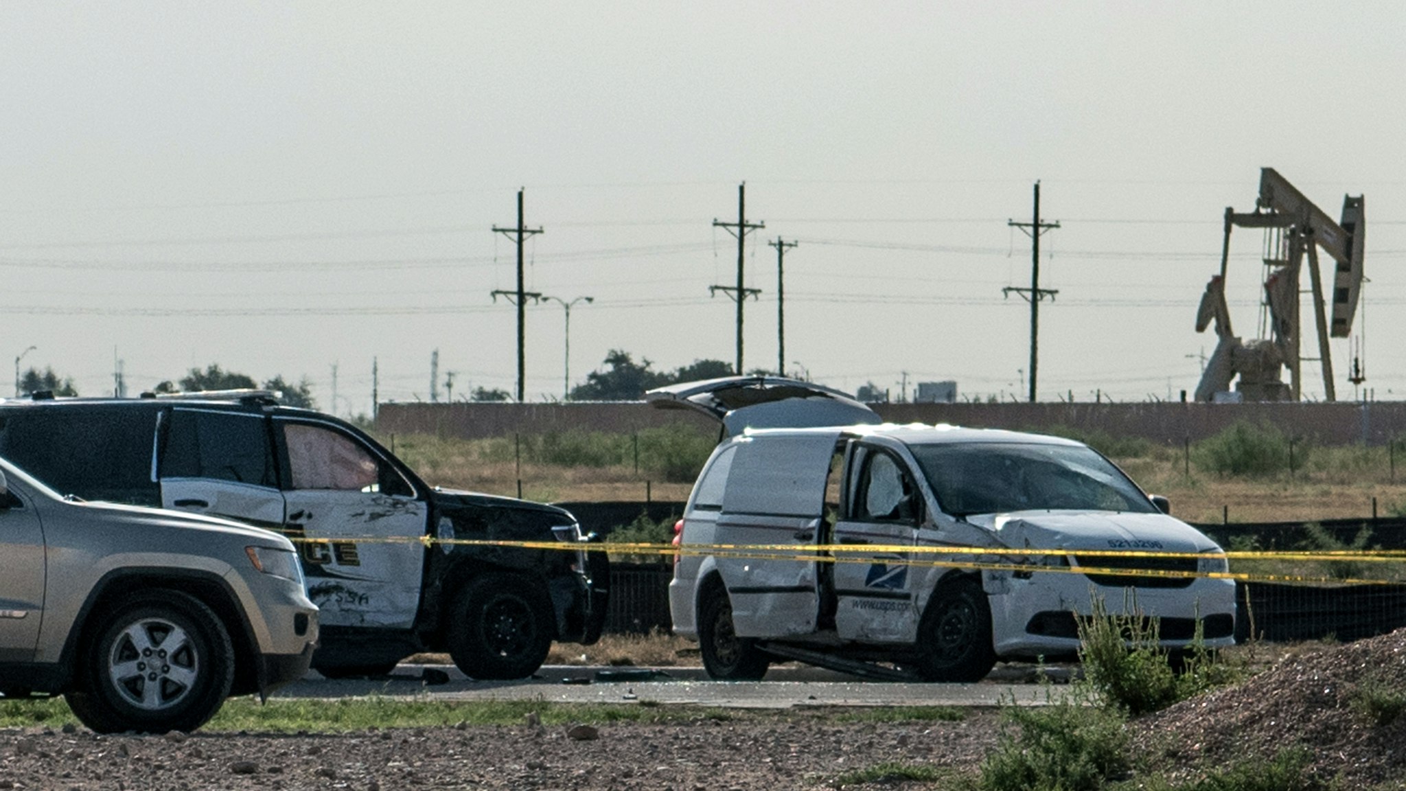 ODESSA, TX - SEPTEMBER 1: A damaged police vehicle and U.S. Postal Service van blocked off with tape nearby to where a gunman was shot and killed at Cinergy Odessa movie theater following a deadly shooting spree on September 1, 2019 in Odessa, Texas.
