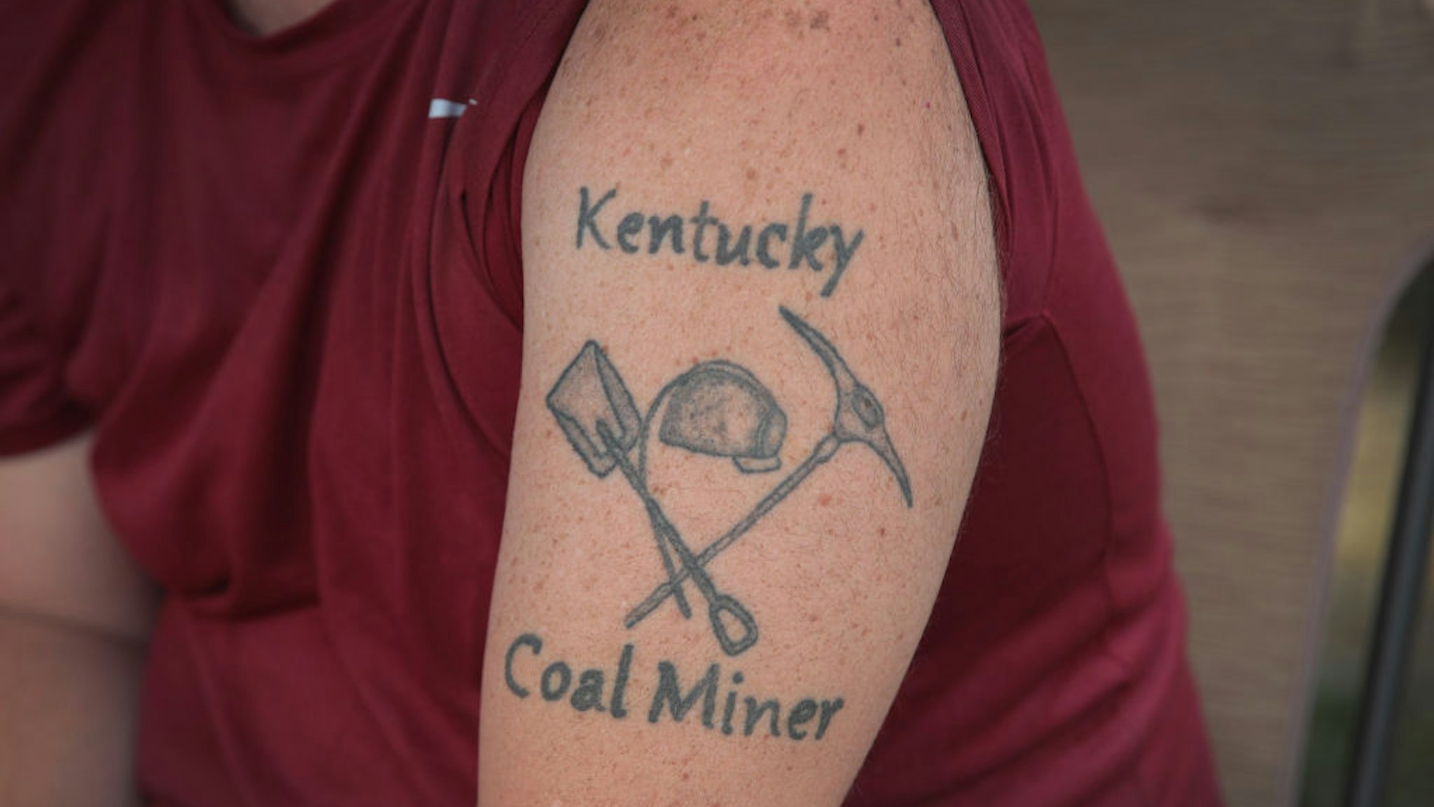 CUMBERLAND, KENTUCKY - AUGUST 08: Unemployed Blackjewel coal miner Chris Lewis shows his tattoo as he participates in a blockade along the railroad tracks that lead to one of Blackjewel's mines on August 08, 2019 near Cumberland, Kentucky. The Blackjewel miners of Harlan County unexpectedly found themselves unemployed when Blackjewel declared bankruptcy and shut down their mines. Just as unexpected was the discovery that the miner's final paychecks had bounced. When a few of the miners learned the company was shipping out a final load of coal by rail they decided to blockade the tracks to prevent the shipment from leaving the mine until they were paid their wages. The blockade, which is in its 11th day, has received a local and national outpouring of support.