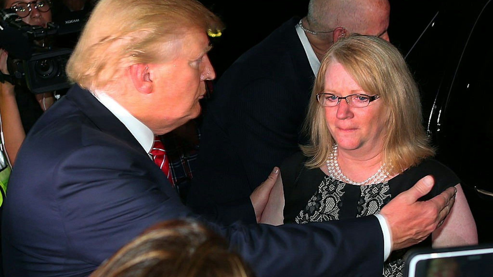 NORWOOD, MA - AUGUST 28: A fundraiser was held at the mansion of car dealer Ernie Boch Jr. for Republican presidential hopeful Donald Trump. As he leaves, Trump hugs a crying Maureen Maloney who's son, Matthew Denice from Milford was killed in 2011 in a m