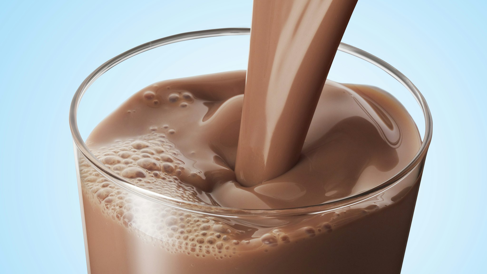 Chocolate milk pouring into a glass.
