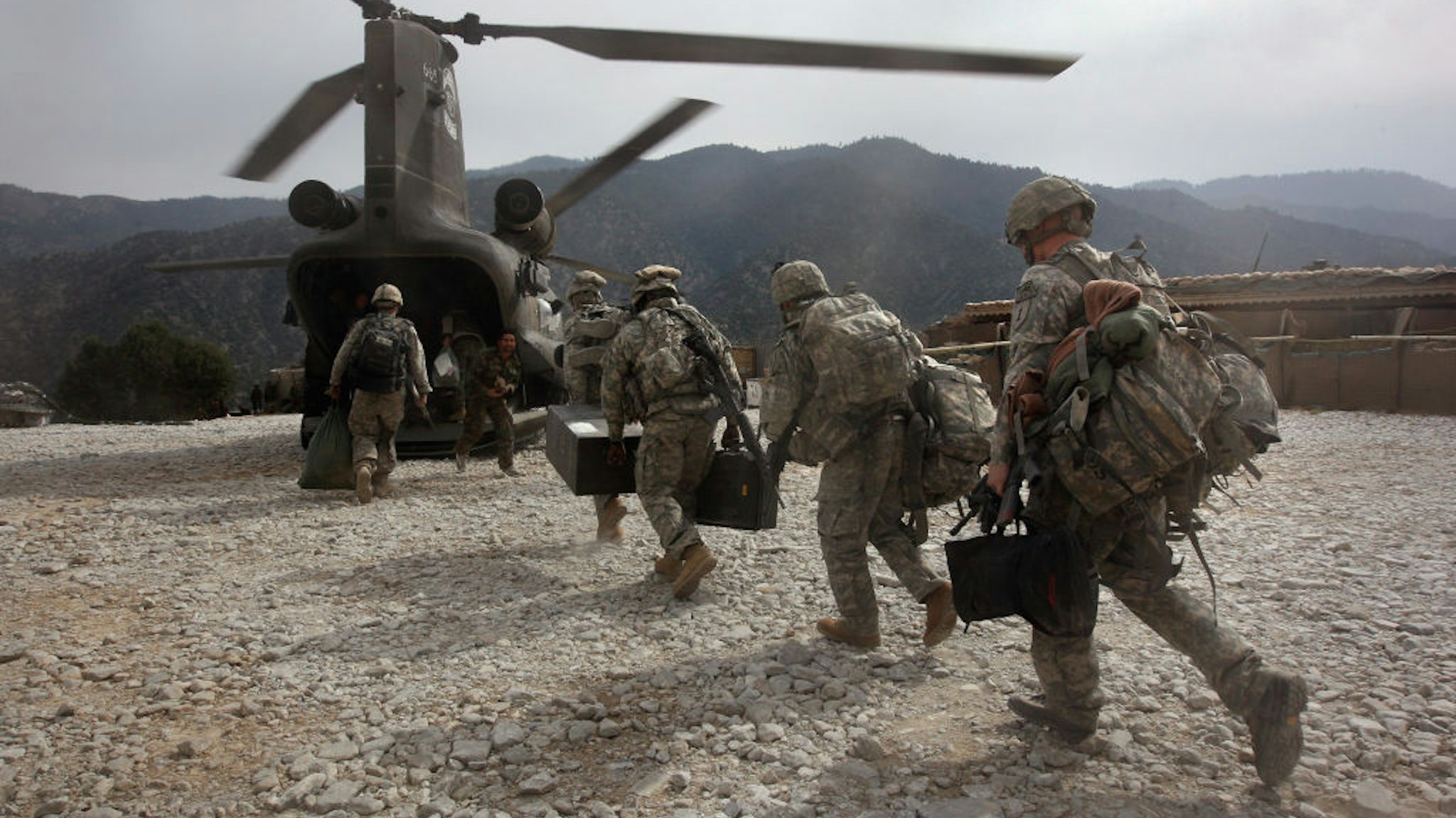 KORENGAL VALLEY, AFGHANISTAN - OCTOBER 27: U.S. soldiers board an Army Chinook transport helicopter after it brought fresh soldiers and supplies to the Korengal Outpost on October 27, 2008 in the Korengal Valley, Afghanistan. The military spends huge effort and money to fly in supplies to soldiers of the 1-26 Infantry based in the Korengal Valley, site of some of the fiercest fighting of the Afghan war. The unpaved road into the remote area is bad and will become more treacherous with the onset of winter.