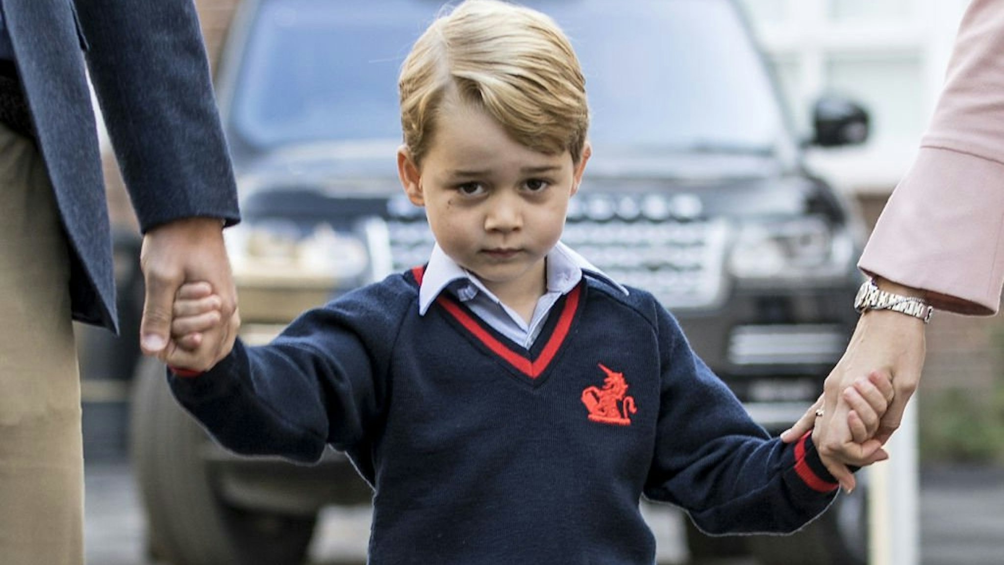 Britain's Prince George (C) accompanied by Britain's Prince William (L), Duke of Cambridge arrives for his first day of school at Thomas's school where he is met by Helen Haslem (R) head of the lower school in southwest London on September 7, 2017.