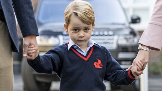 Britain's Prince George (C) accompanied by Britain's Prince William (L), Duke of Cambridge arrives for his first day of school at Thomas's school where he is met by Helen Haslem (R) head of the lower school in southwest London on September 7, 2017.