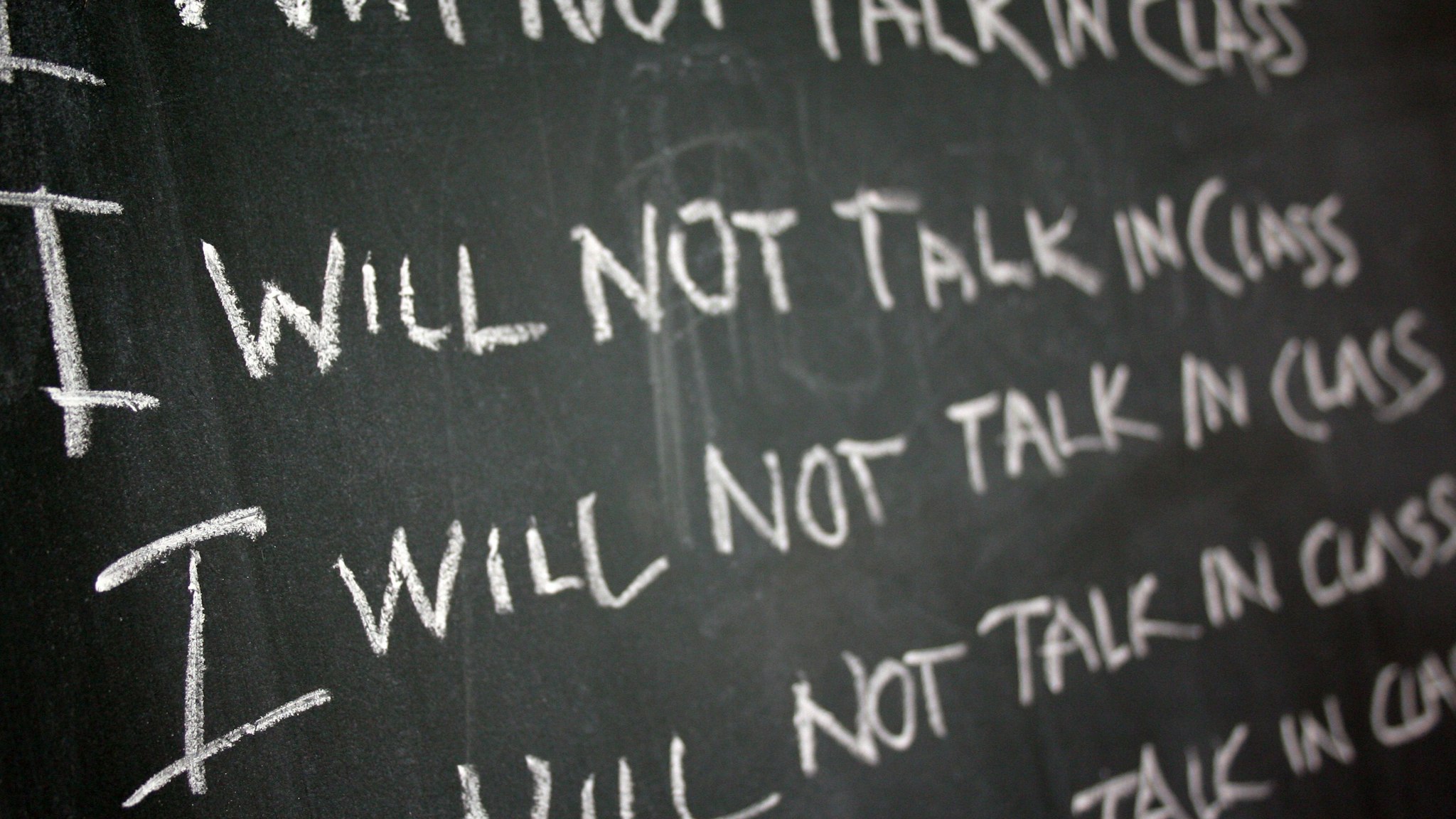 Chalk board reading "I will not talk in class"