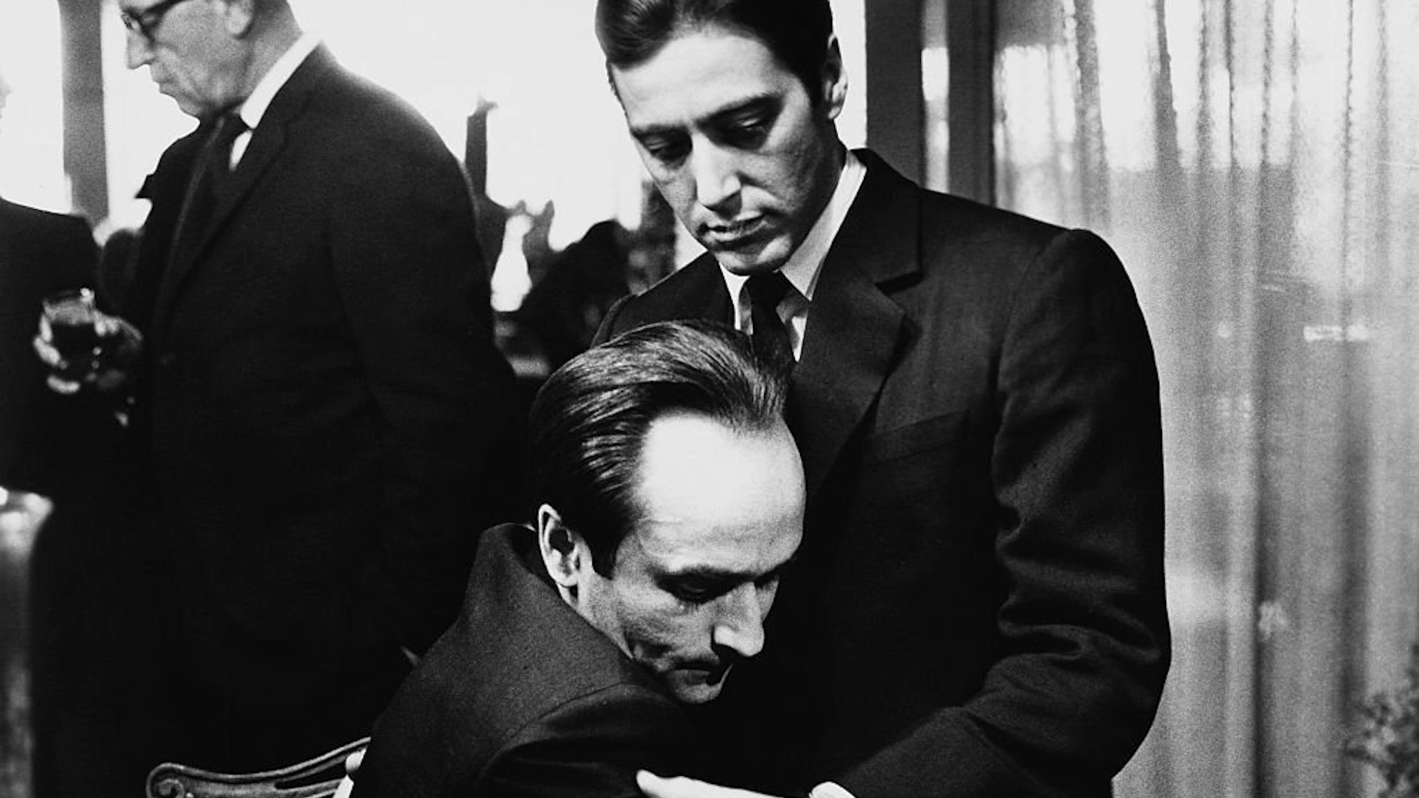 Frederico "Fredo" Corleone (John Cazale) holds his brother Michael Corleone (Al Pacino) at a family funeral in Francis Ford Coppola's The Godfather: Part II.