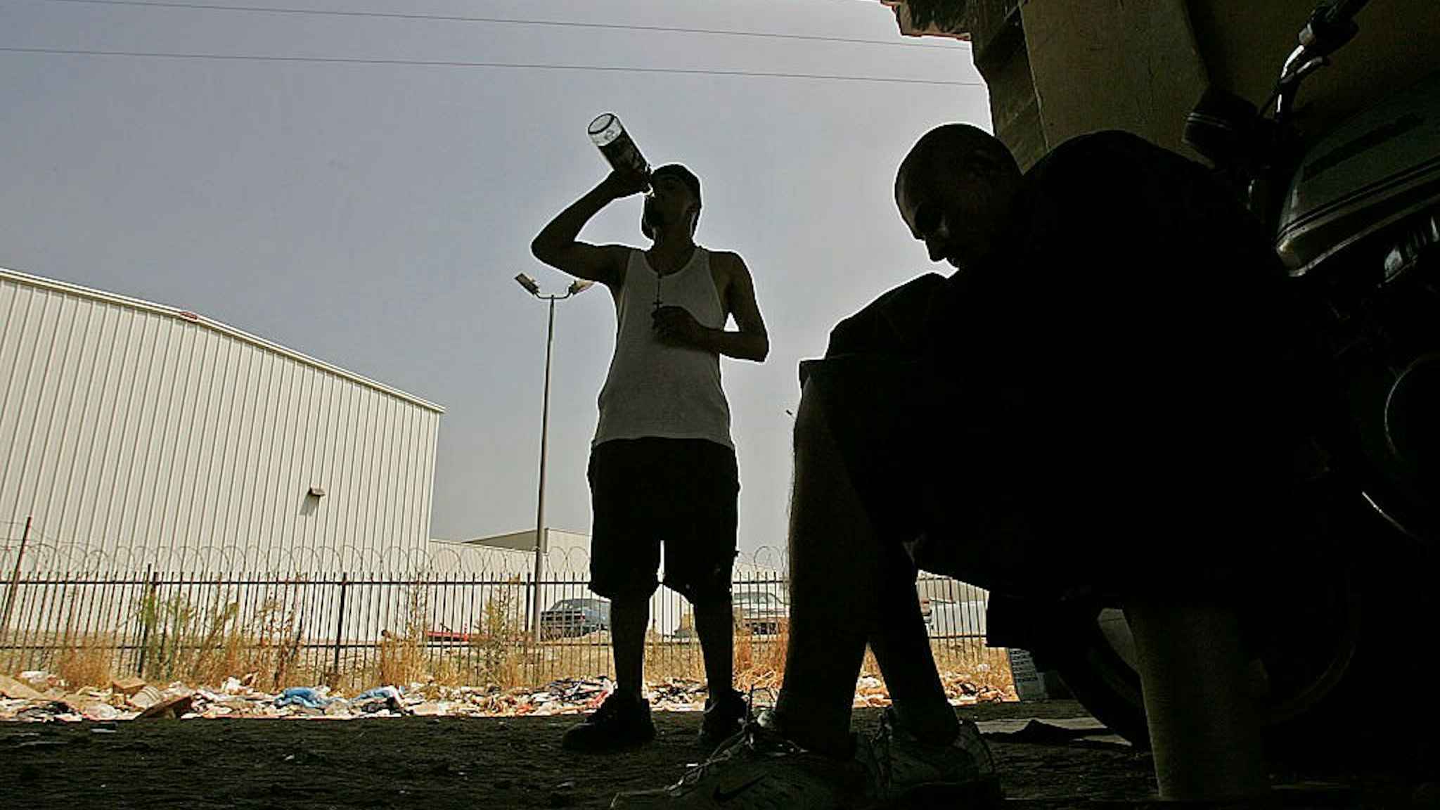 srael and Erasmus, a pair of homeless drug addicts, share a boittle of malt liquor at their encampment in downtown Los Angeles.