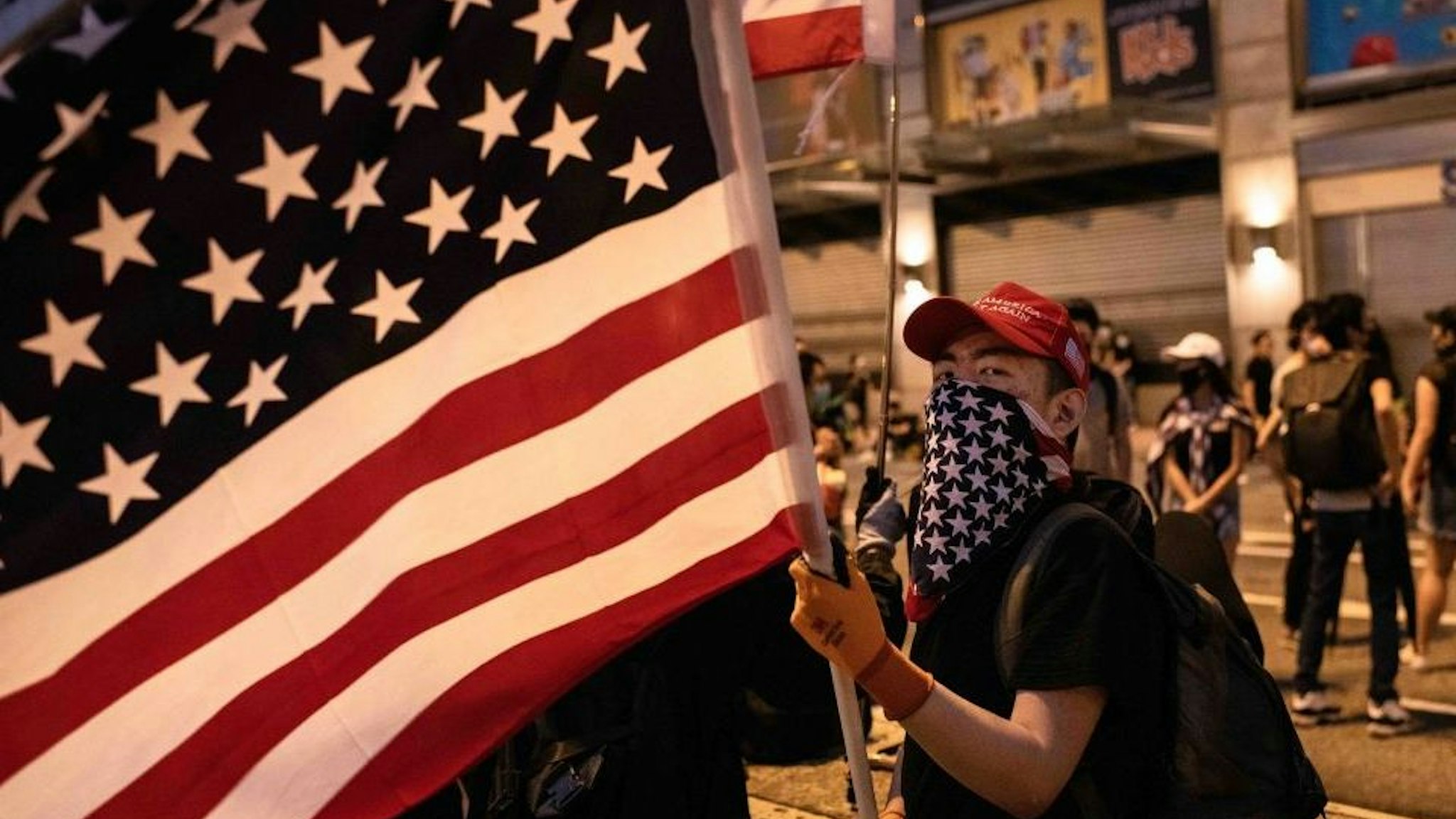 Demonstrator waves an American flag during the protest. KOWLOON, HONG KONG, HONG KONG SAR, CHINA