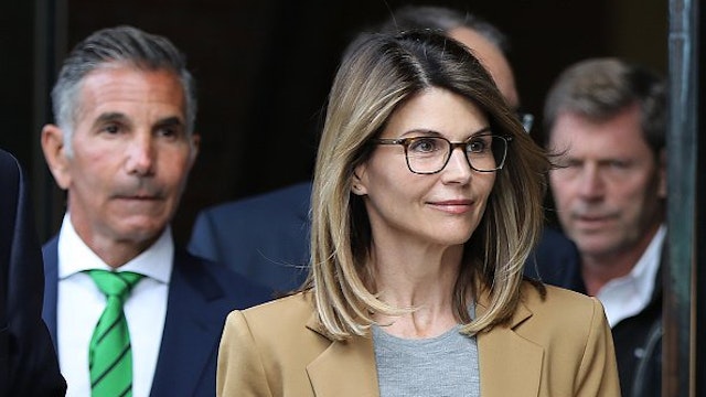 Actress Lori Loughlin and her husband Mossimo Giannulli, wearing green tie at left, leave the John Joseph Moakley United States Courthouse in Boston on April 3, 2019.