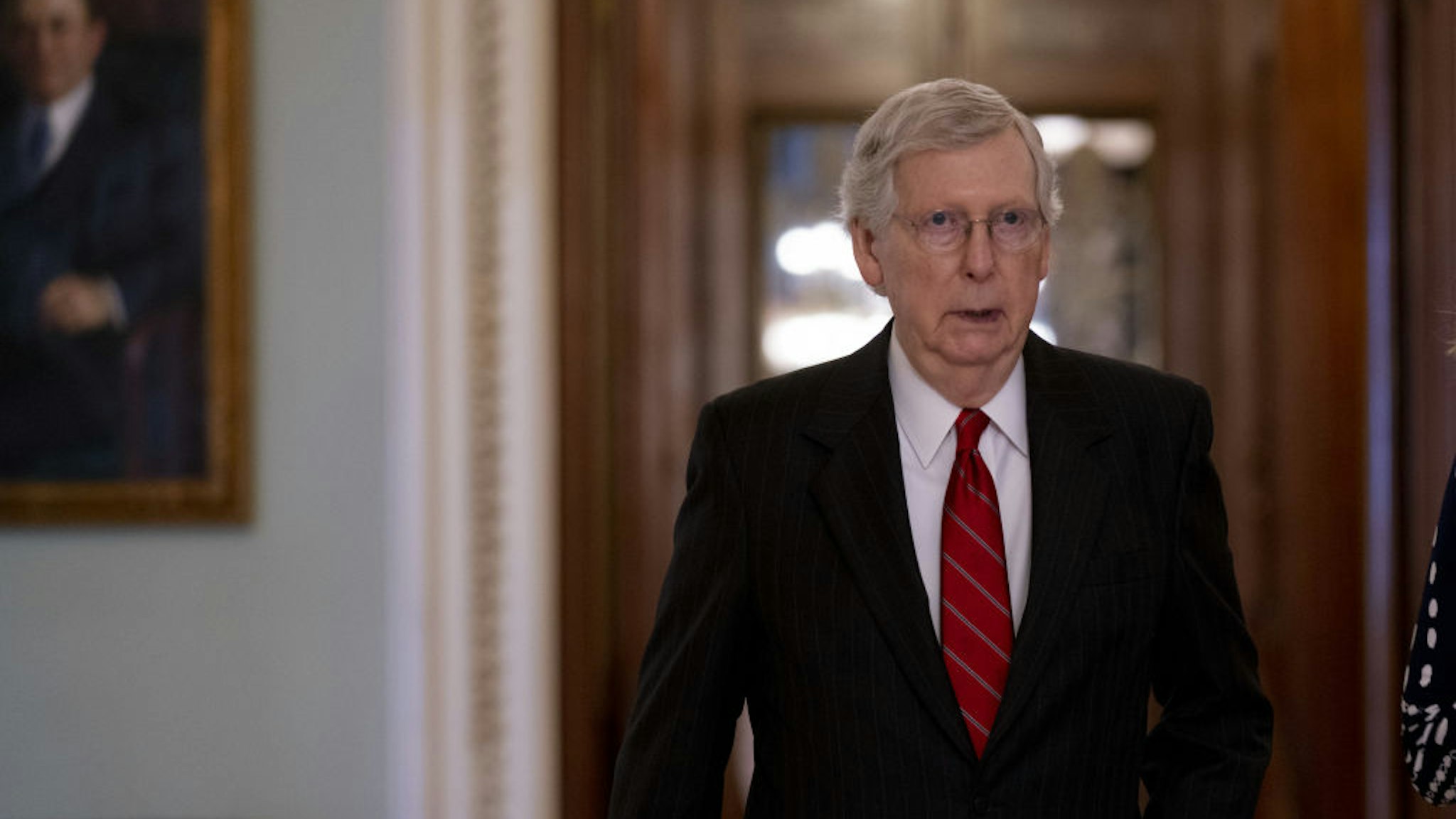 Senate Majority Leader Mitch McConnell walks toward his office after voting in the Senate Chamber