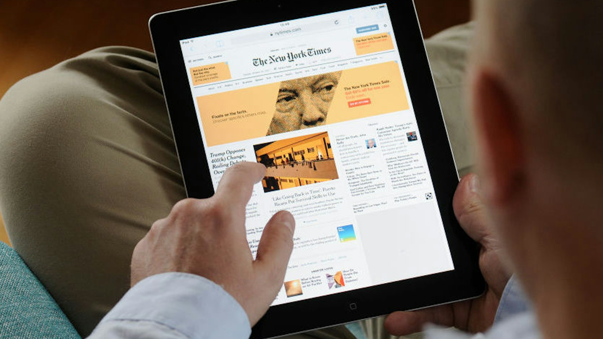 A man is seen reading the New York Times on an iPad on October 24, 2017.