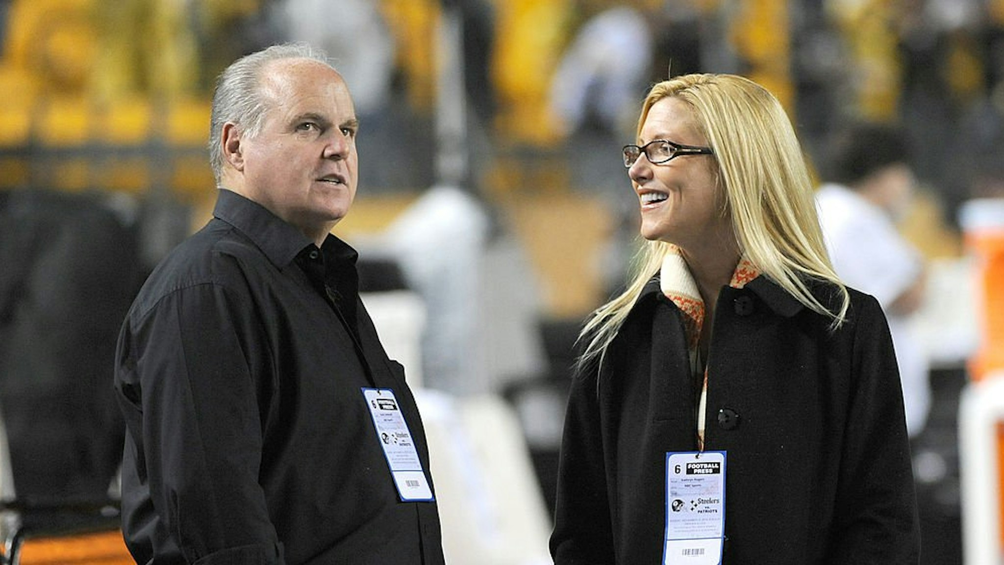 Radio talk show host and political commentator Rush Limbaugh (L) and his wife, Kathryn Rogers, look on from the sideline before a National Football League game between the New England Patriots and Pittsburgh Steelers at Heinz Field on November 14, 2010.