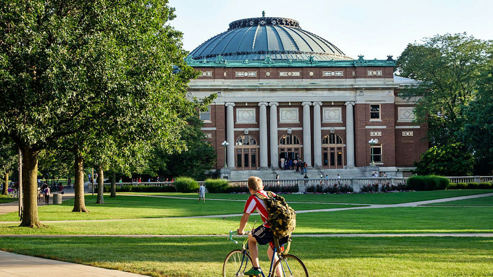 Student boy riding bicycle on campus of the University of Illinois.