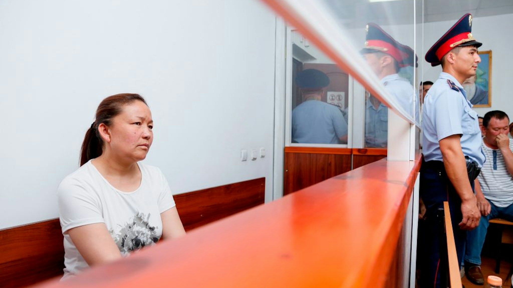 A picture taken on July 13, 2018 shows Sayragul Sauytbay, 41, an ethnic Kazakh Chinese national and former employee of the Chinese state, who is accused of illegally crossing the border between the countries to join her family in Kazakhstan, sits inside a defendants' cage during a hearing at a court in the city of Zharkent.