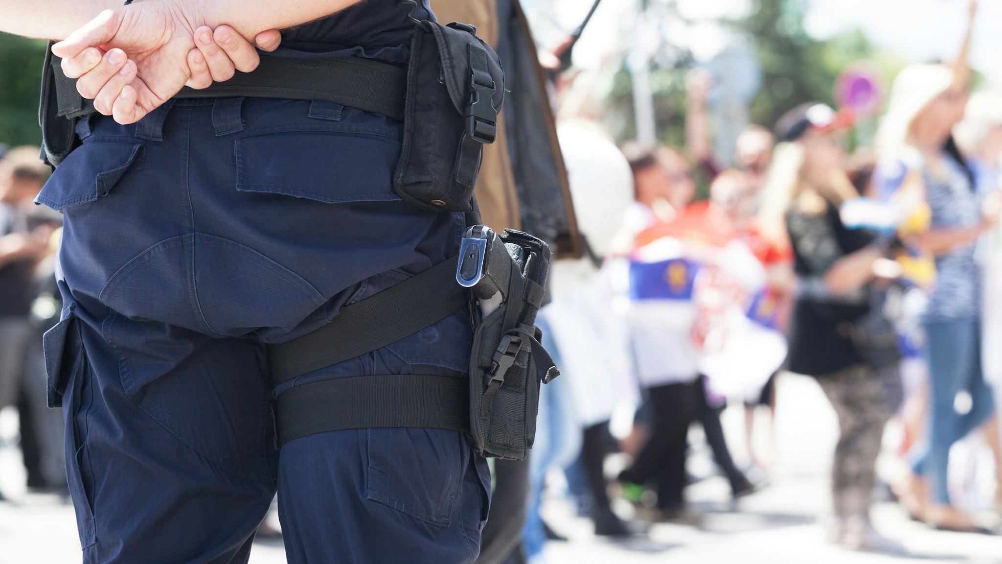 Midsection Of Police Force Against Crowd During Protest - stock photo