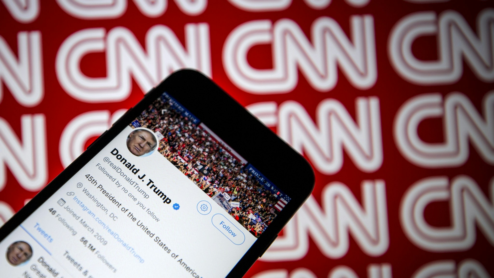 Donald Trump's Twitter profile is seen on a smartphone against a backdrop with the CNN logo, in Ankara, Turkey on December 9, 2018.