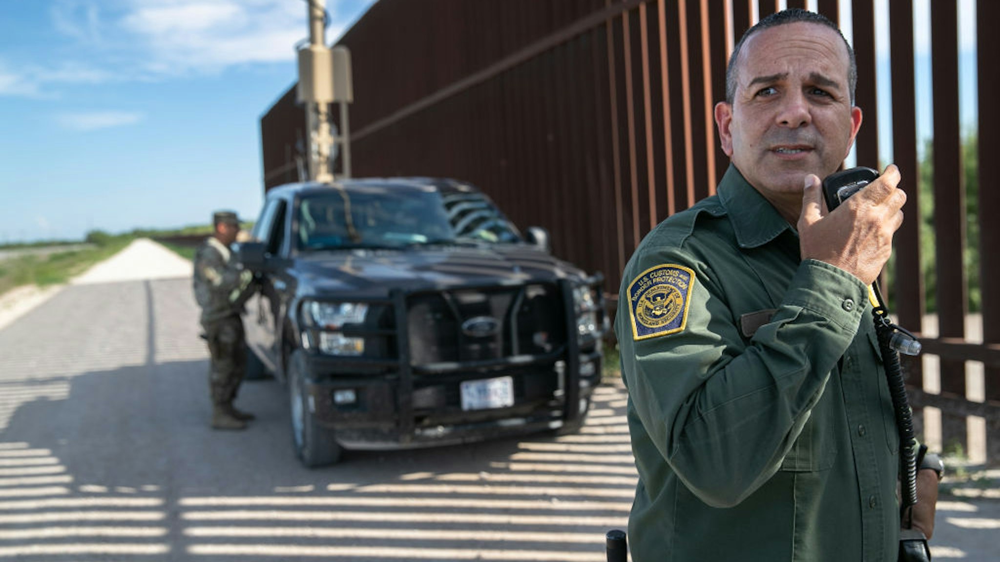 U.S. Border Patrol agent Carlos Ruiz spots a pair of undocumented immigrants while coordinating with active duty U.S. Army soldiers near the U.S.-Mexico border fence on September 10, 2019 in Penitas, Texas.