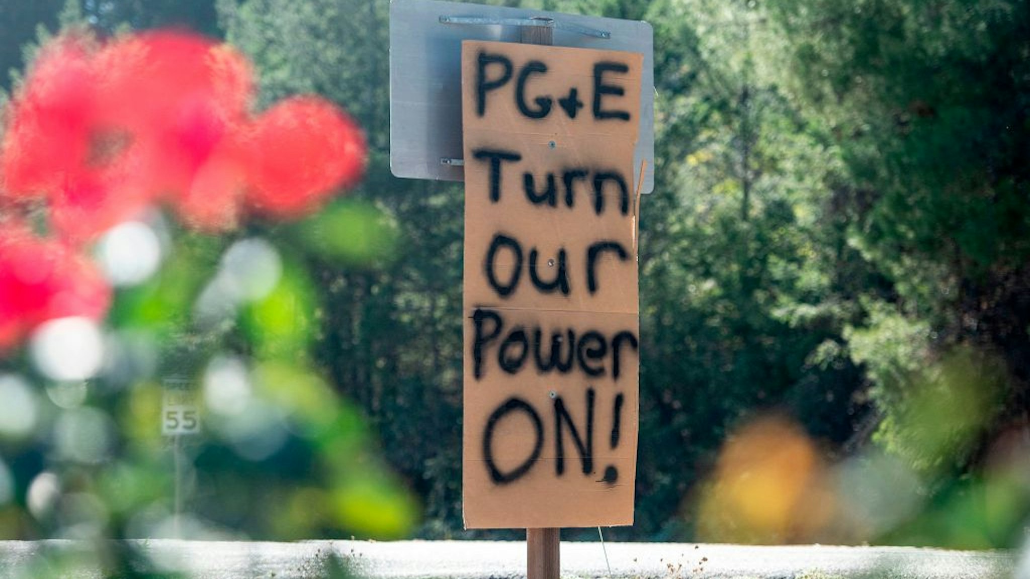 A sign calling for utility company PG&E to turn the power back on is seen on the side of the road during a statewide blackout in Calistoga, California, on October, 10, 2019