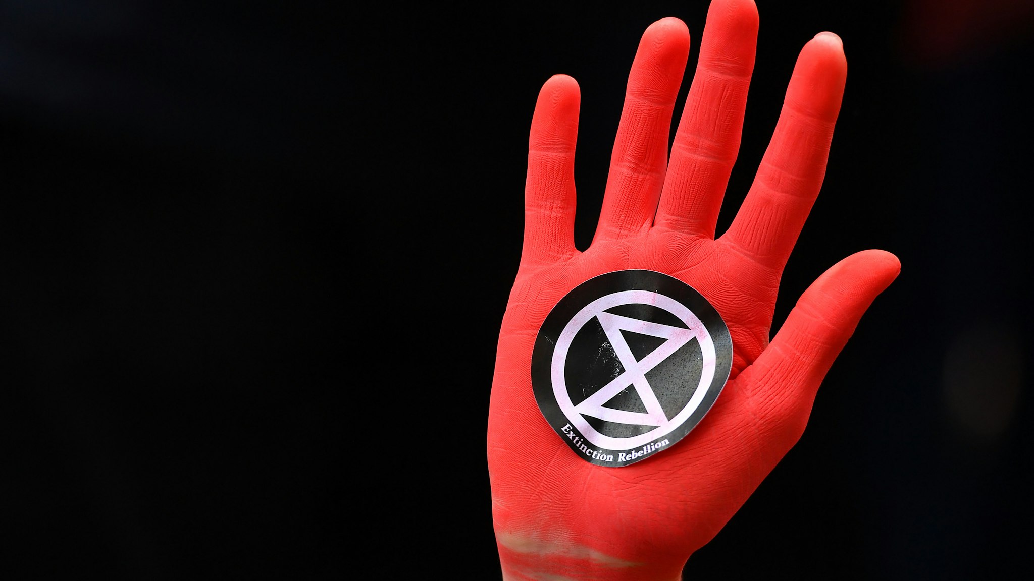 A protesters hand sprayed red in Westminster, London, during an Extinction Rebellion (XR) climate change protest. (Photo by Dominic Lipinski/PA Images via Getty Images)