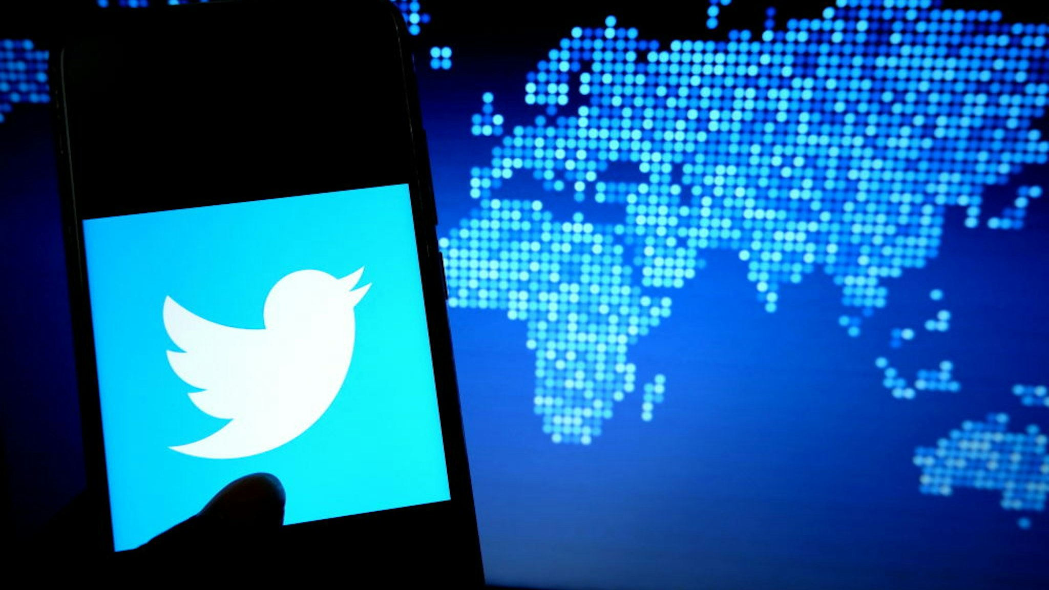In this photo illustration a popular micro blogging and social networking service Twitter logo displayed on a smartphone.