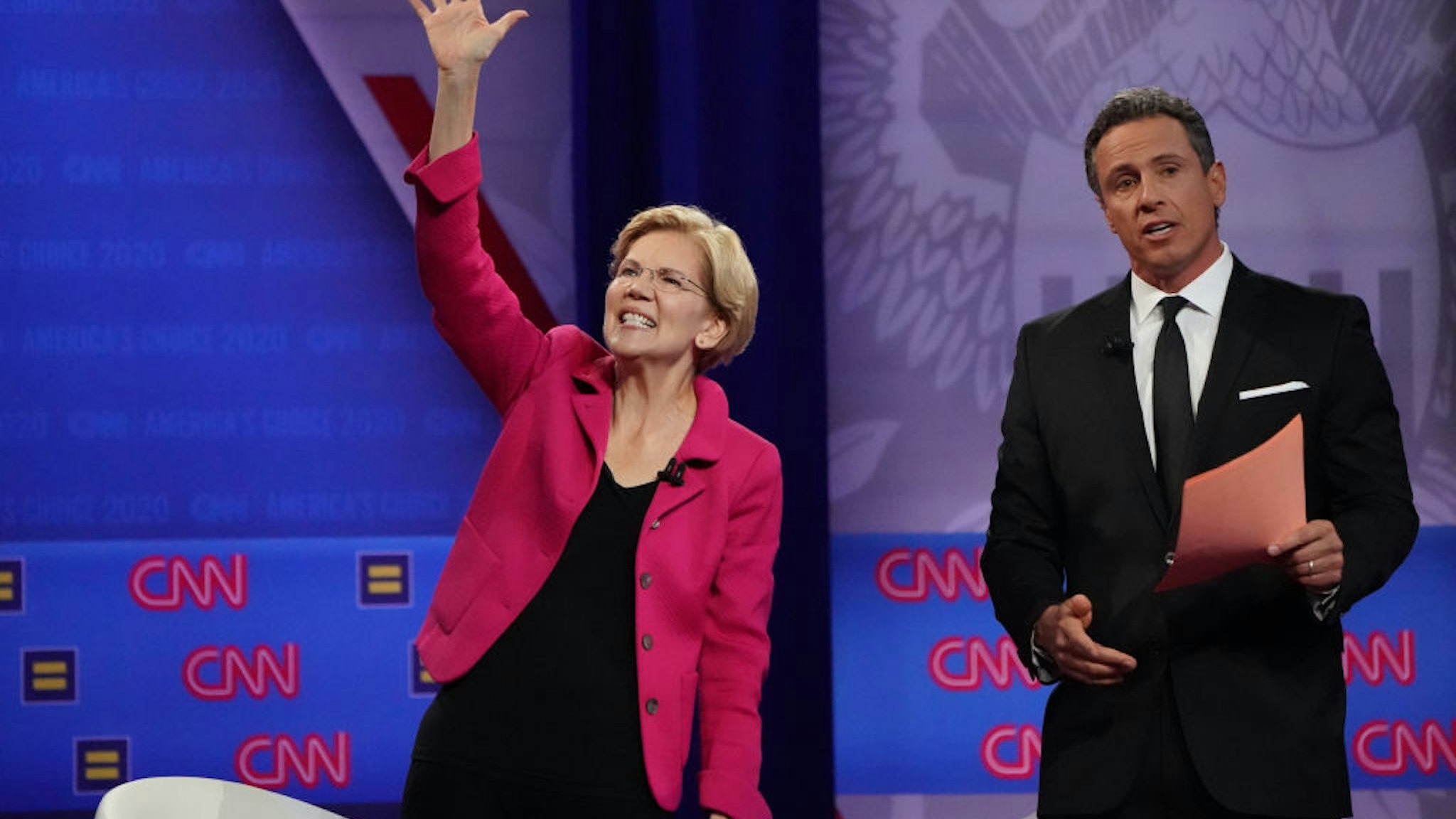 Democratic presidential candidate Sen. Elizabeth Warren (D-MA), L, waves as CNN moderator Chris Cuomo looks on at the Human Rights Campaign Foundation and CNN’s presidential town hall focused on LGBTQ issues on October 10, 2019 in Los Angeles, California.