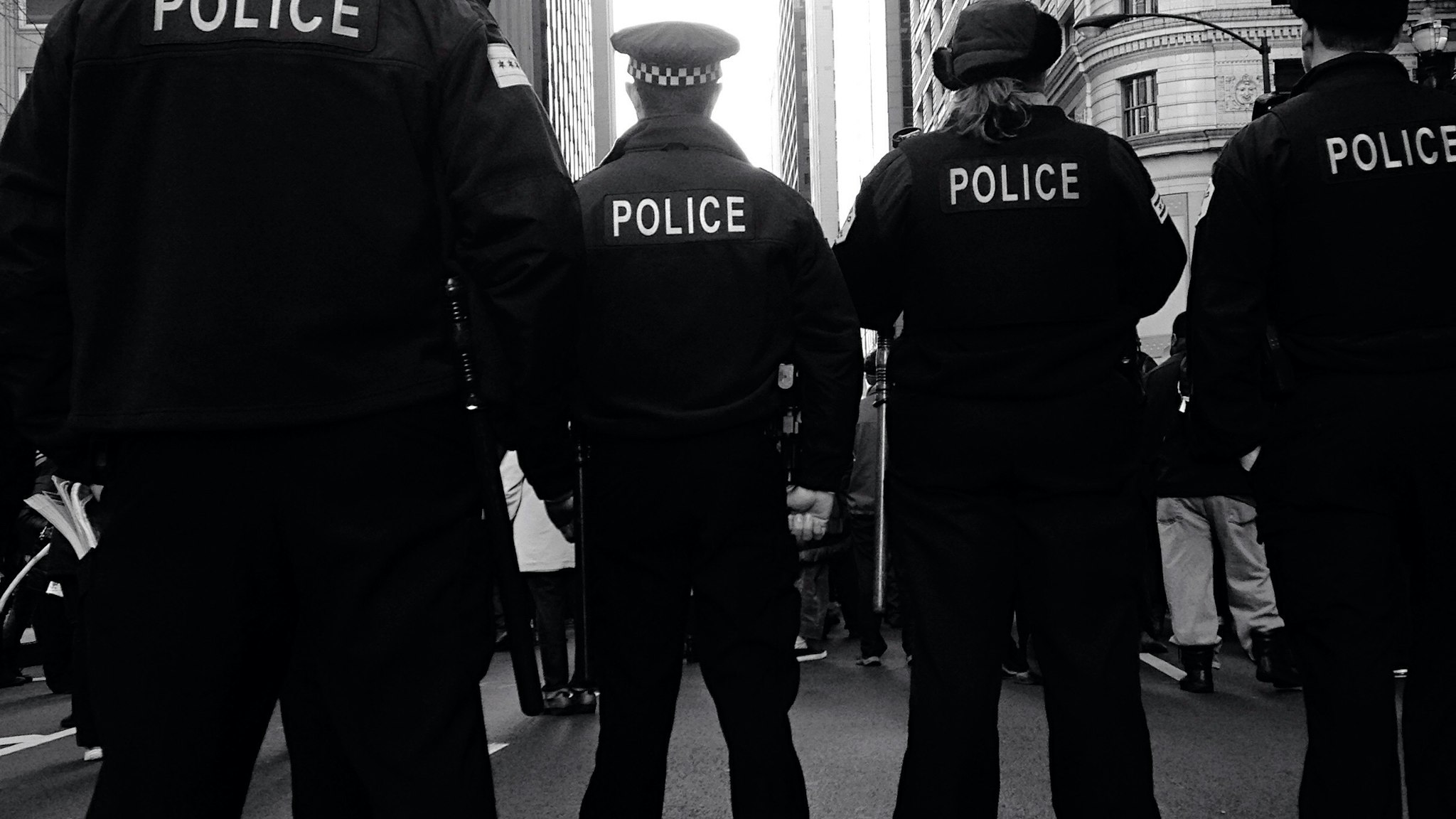 Rear View Of Police Force Standing On Street Against Buildings In City - stock photo
