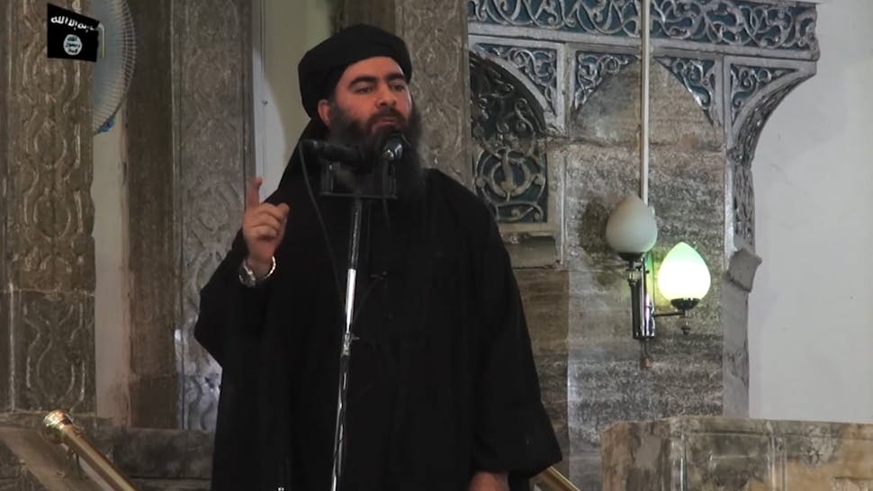 IRAQ-IS-AL-BAGHDADI This July 5, 2014 photo shows an image grab taken from a propaganda video released by al-Furqan Media allegedly showing the leader of the Islamic State (IS) jihadist group, Abu Bakr al-Baghdadi, aka Caliph Ibrahim, adressing Muslim worshippers at a mosque in the militant-held northern Iraqi city of Mosul. Baghdadi, who on June 29 proclaimed a "caliphate" straddling Syria and Iraq, purportedly ordered all Muslims to obey him in the video released on social media. - In early 2014 the self-styled Islamic State entered the northern Syrian city of Raqqa, declaring it their capital and beginning a reign of terror marked by grisly public executions. Armed sharia police patrolled the streets as "enemies" of the regime were crucified or decapitated, their severed heads impaled on spikes in the city square. (Photo by - / AFP) (Photo by -/AFP via Getty Images)