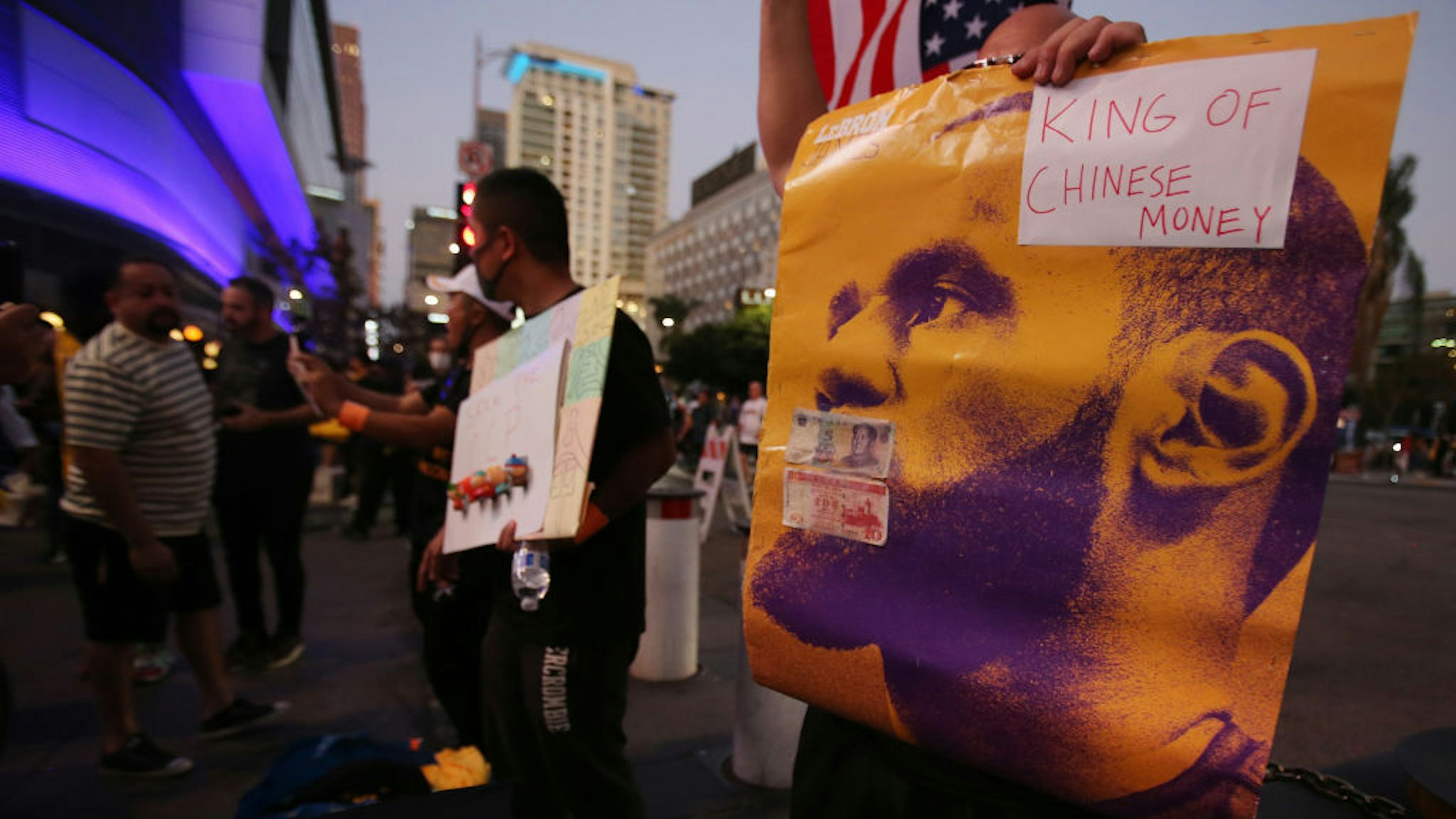 A pro-Hong Kong activist holds a poster of LeBron James with the words 'King of Chinese Money' before the Los Angeles Lakers season opening game against the LA Clippers outside Staples Center on October 22, 2019 in Los Angeles, California. Activists also printed at least 10,000 pro-Hong Kong t-shirts to hand out to those attending the game and encouraged them to wear the free shirts as a form of peaceful protest against China amidst Chinese censorship of NBA games. (Photo by Mario Tama/Getty Images)