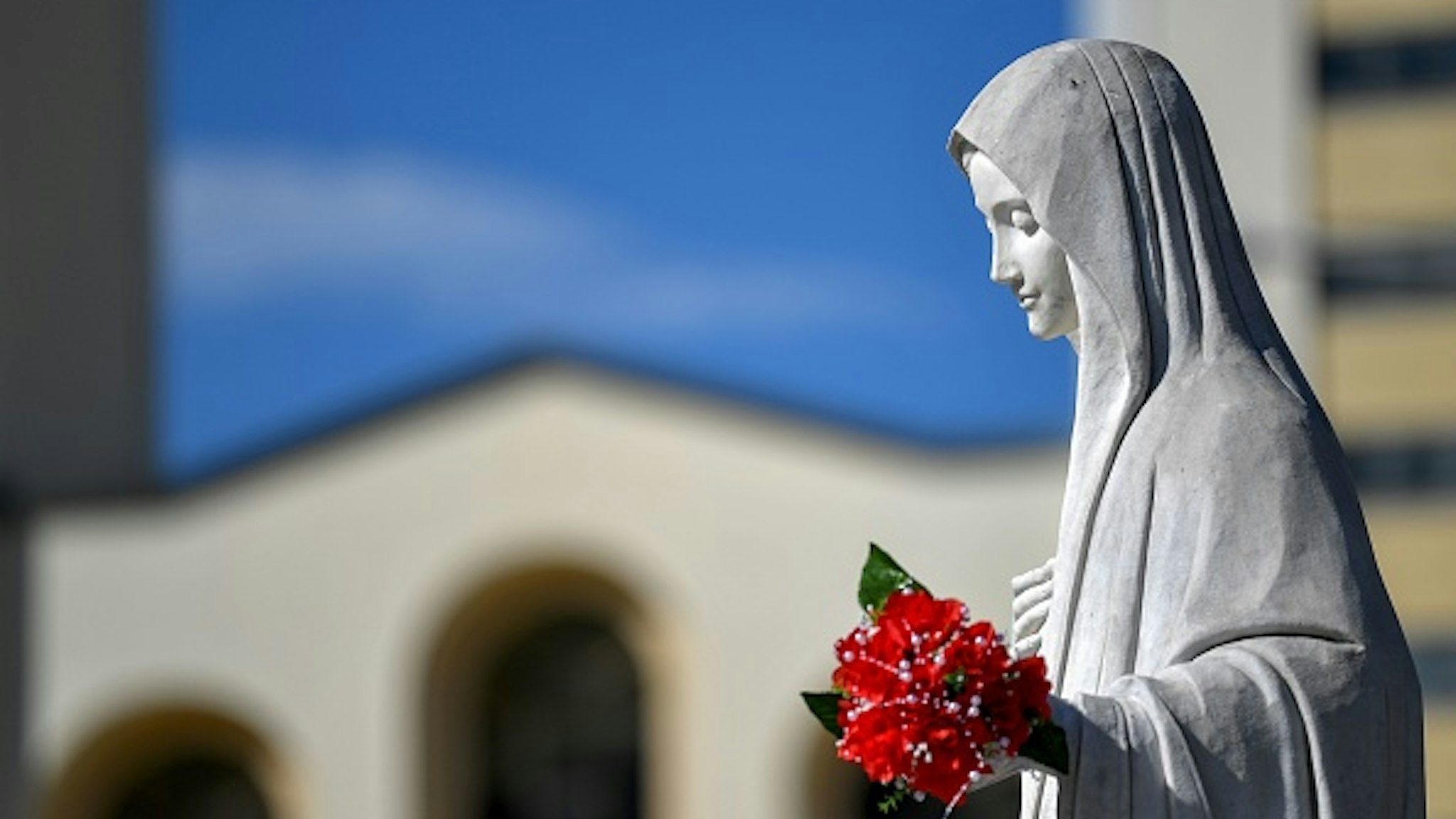 This picture taken on June 26, 2019 shows a statue of Virgin Marry, in front of Franciscan church of St. Jacob, in Southern-Bosnian village of Medjugorje. - The Bosnian town of Medjugorje has become an unofficial site of Catholic pilgrimage since the supposed apparition of Virgin Mary in front of children on a nearby hill, 38 years ago. According to some of the pilgrims, Medjugorje is as sacred as Lourdes or Fatima.