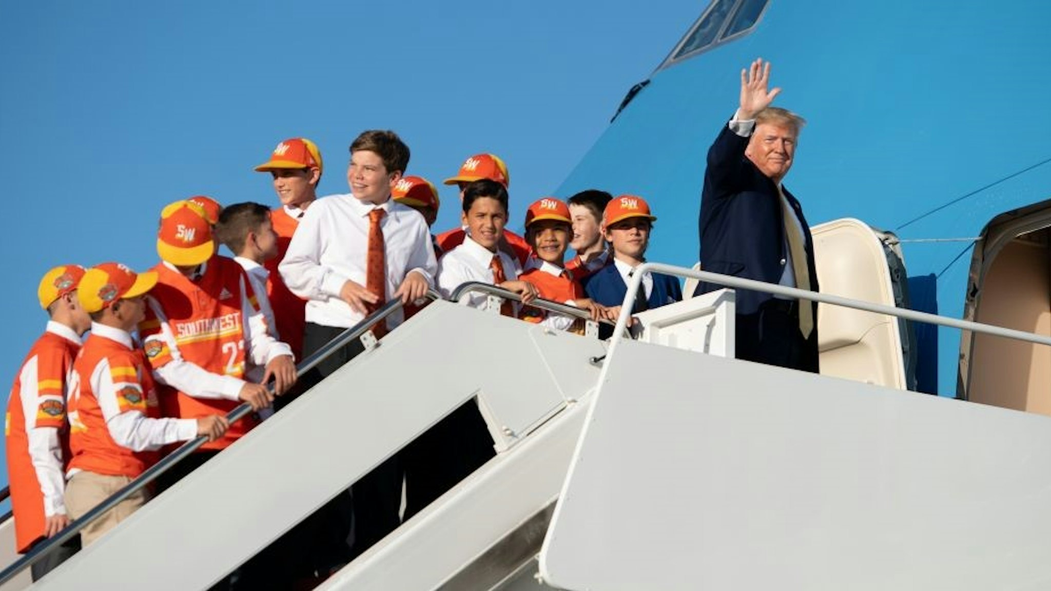 US President Donald Trump boards Air Force One with members of the Little League World Championship baseball team, the Eastbank All Stars of Louisiana, prior to departure from Joint Base Andrews in Maryland, October 11, 2019, as he travels to Louisiana, to hold a campaign rally. (Photo by SAUL LOEB / AFP) (Photo by SAUL LOEB/AFP via Getty Images)