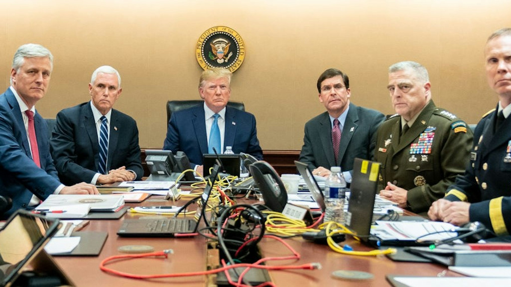 In this handout photo provided by the White House, President Donald J. Trump is joined by Vice President Mike Pence (2nd L), National Security Advisor Robert O’Brien (L), Secretary of Defense Mark Esper (3rd R), Chairman of the Joint Chiefs of Staff U.S. Army General Mark A. Milley (2nd R) and Brig. Gen. Marcus Evans, Deputy Director for Special Operations on the Joint Staff in the Situation Room of the White House October 26, 2019 in Washington, DC. The President was monitoring developments as U.S. Special Operations forces close in on ISIS leader Abu Bakr al-Baghdadi’s compound in Syria with a mission to kill or capture the terrorist. (Photo by Shealah Craighead/The White House via Getty Images)