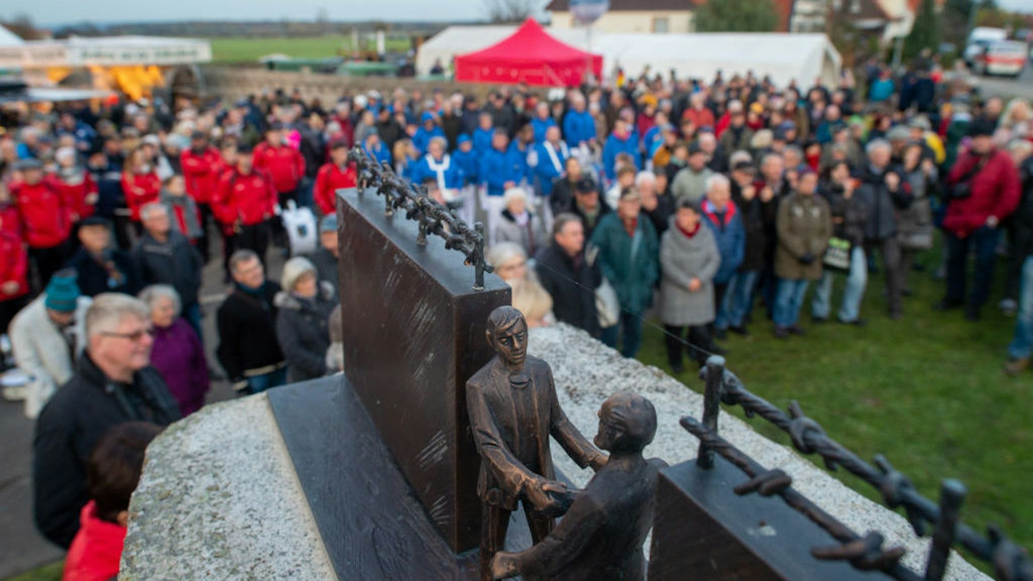11 November 2019, Saxony-Anhalt, Stapelburg: Participants of a festive event stand at the border monument. There people celebrated the fall of the wall 30 years ago. The border in Stapelburg had been opened on 11 November 1989. Photo: Klaus-Dietmar Gabbert/dpa-Zentralbild/dpa (Photo by Klaus-Dietmar Gabbert/picture alliance via Getty Images)