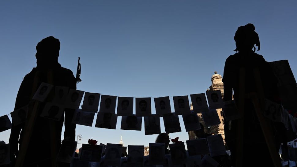 Drug Cartel Violence Pictures of missing persons hang from a rope in front of the National Palace during the commemoration of the International Day of the Disappeared in Mexico City, on August 30, 2019. - More than 40,000 people are missing in Mexico, which has been swept by a wave of violence since the government declared war on the country's powerful drug cartels in 2006. (Photo by RODRIGO ARANGUA / AFP) (Photo credit should read RODRIGO ARANGUA/AFP via Getty Images)